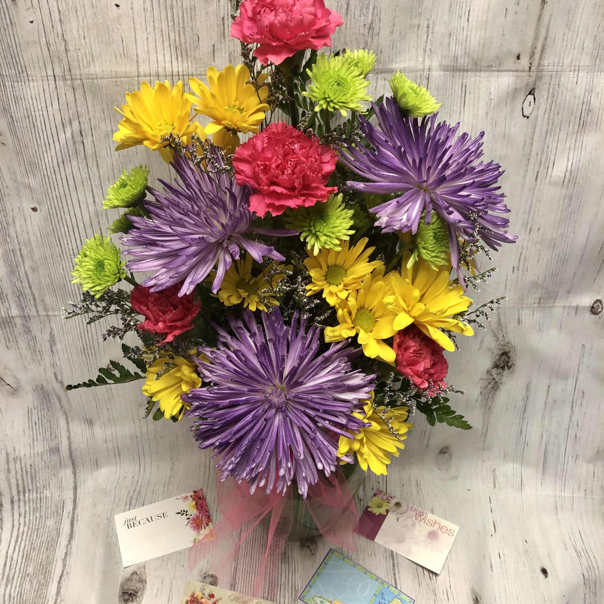 Colorful bouquet of purple, yellow, and pink flowers in a vase