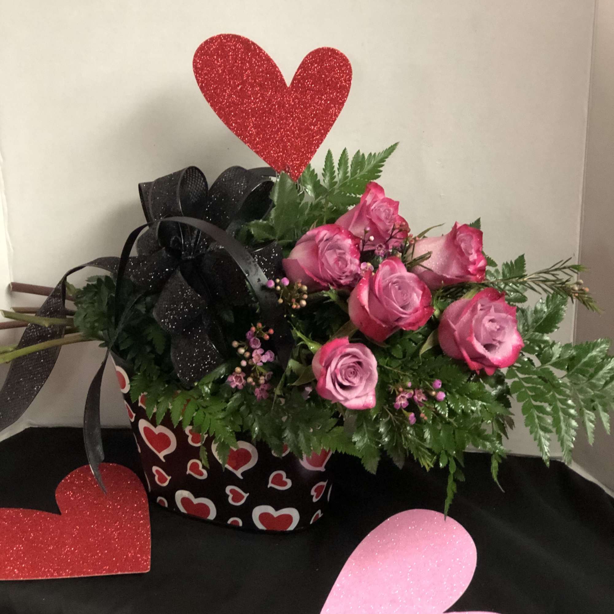 Pink roses in a heart-patterned box with glitter heart picks