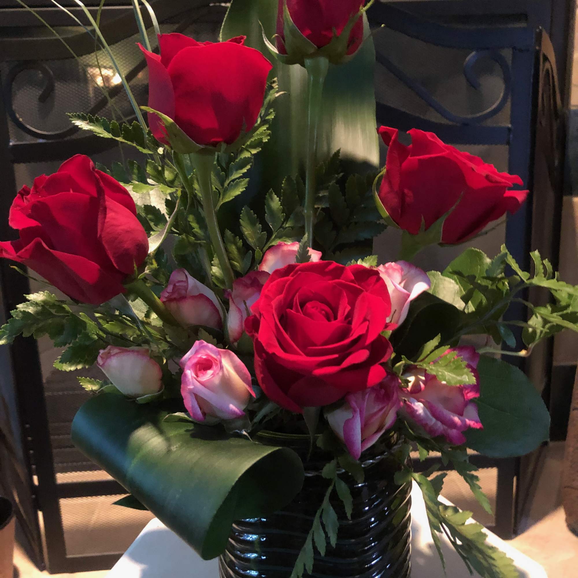 Red and pink roses arranged in a black vase