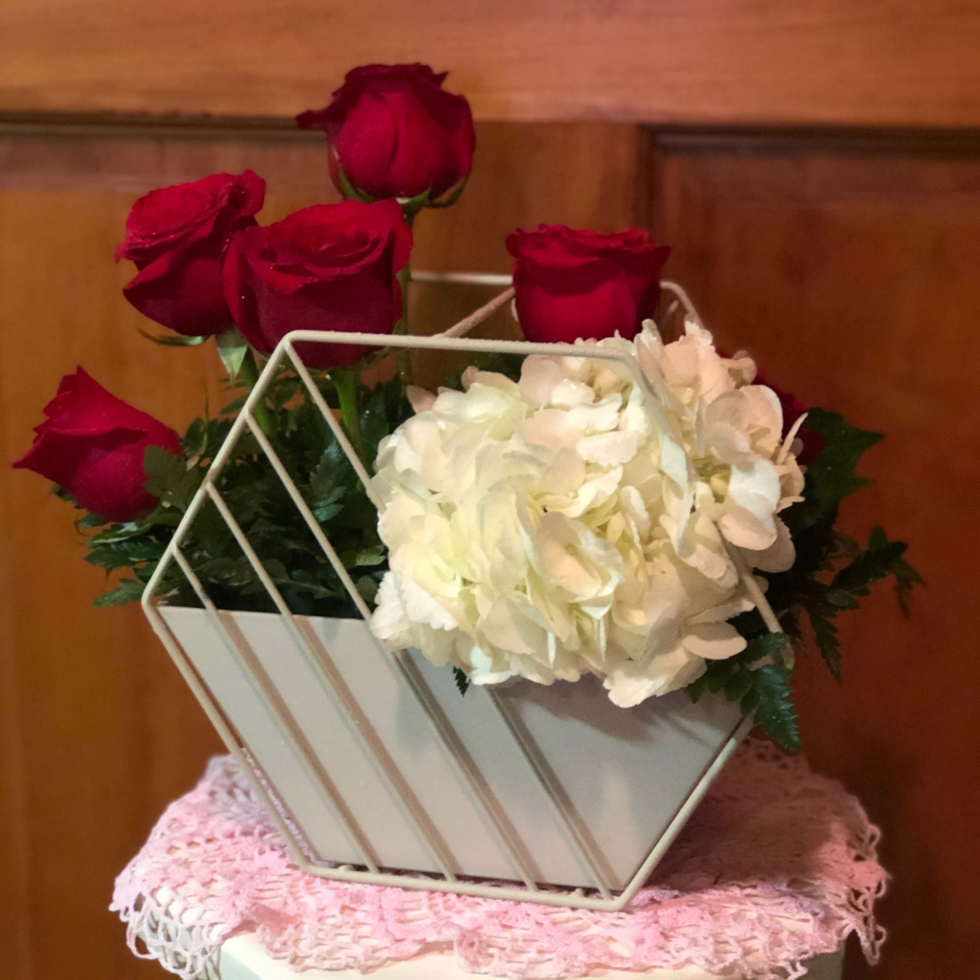 Red roses and white hydrangea in a geometric white container