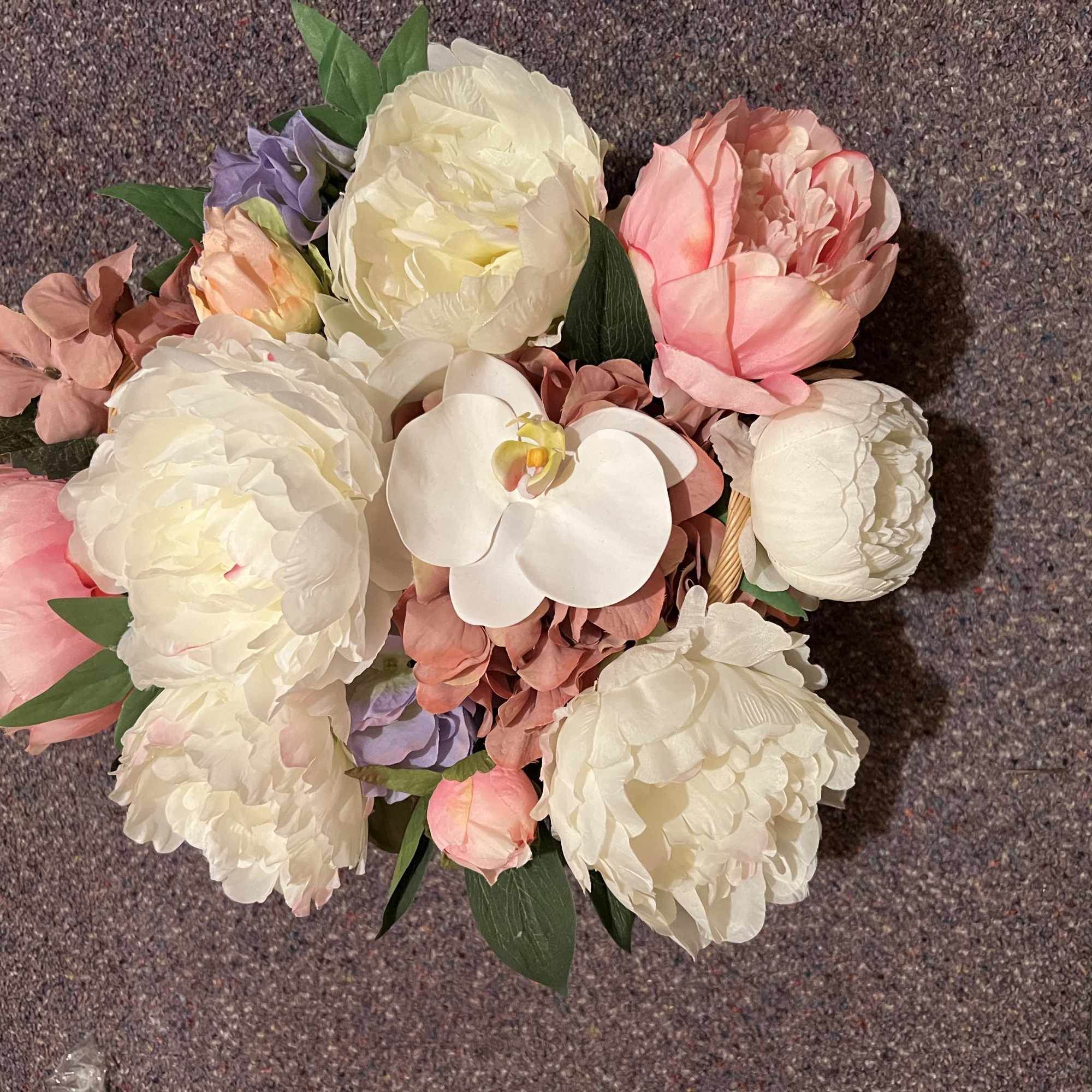 Bouquet of white and pink flowers with a white orchid center