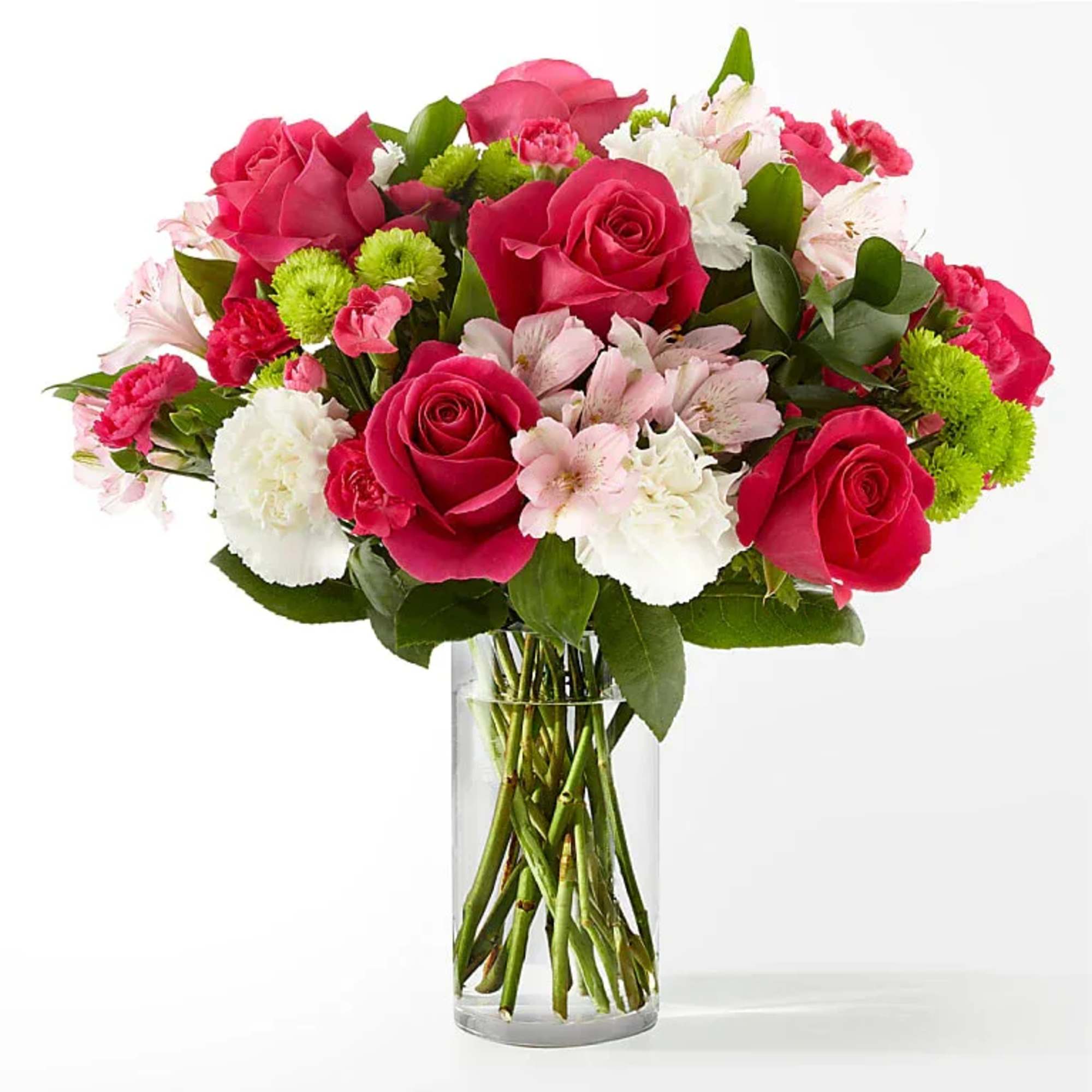 Bouquet of pink roses, white carnations, and green pompons in a glass vase