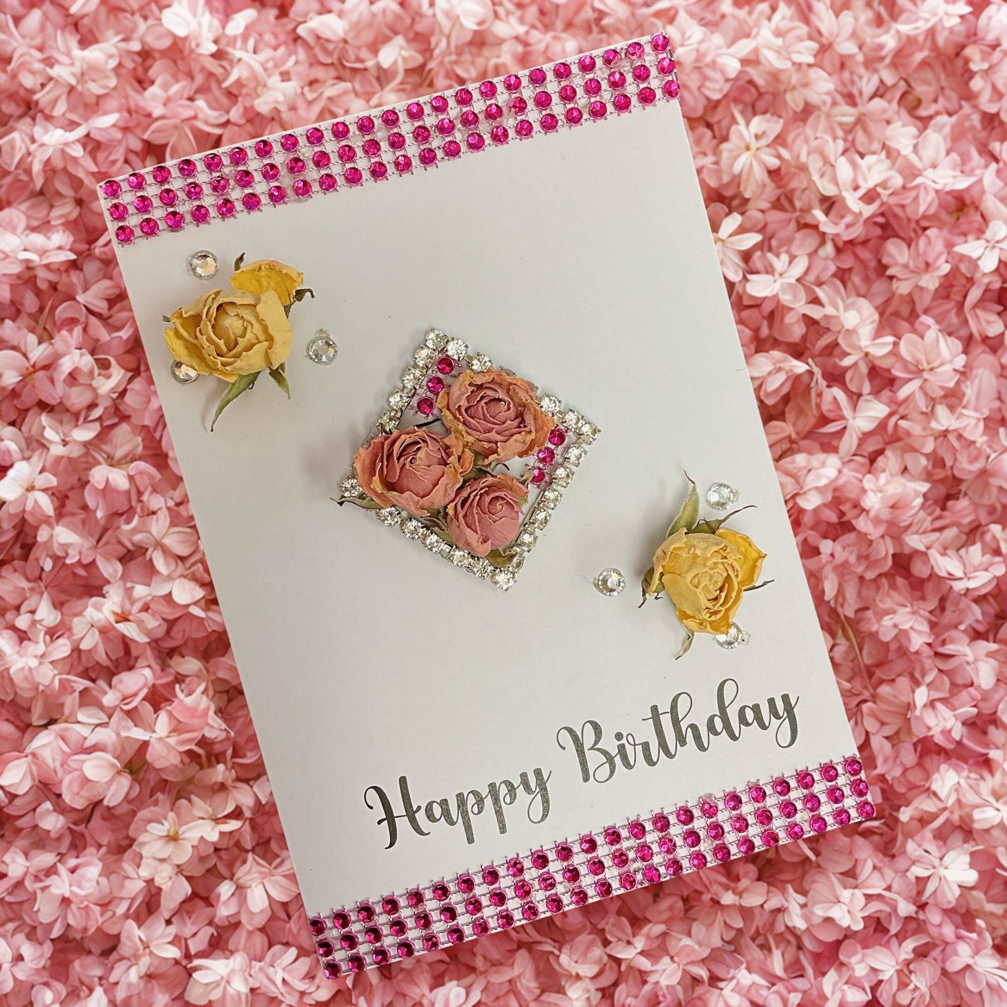 Handmade Happy Birthday card with dried roses and pink rhinestones on a pink floral background