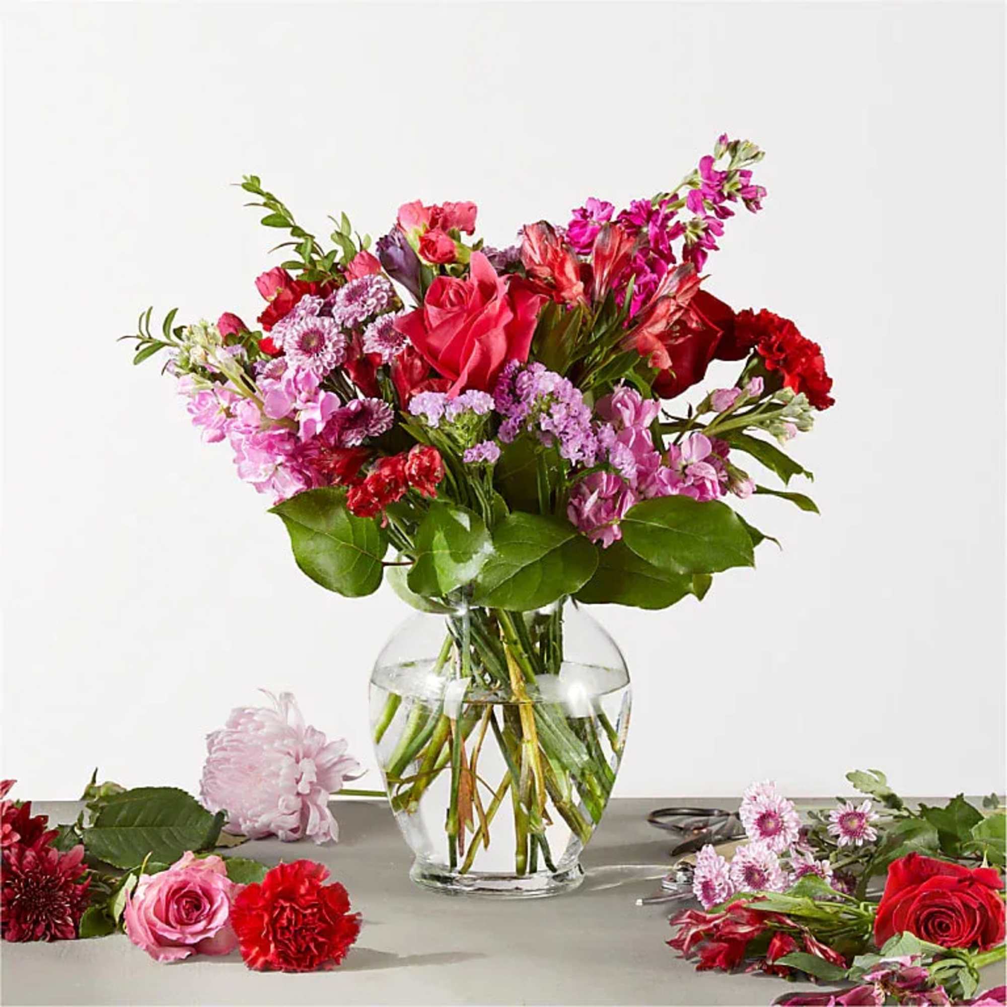 Mixed pink and red flower bouquet in a clear glass vase