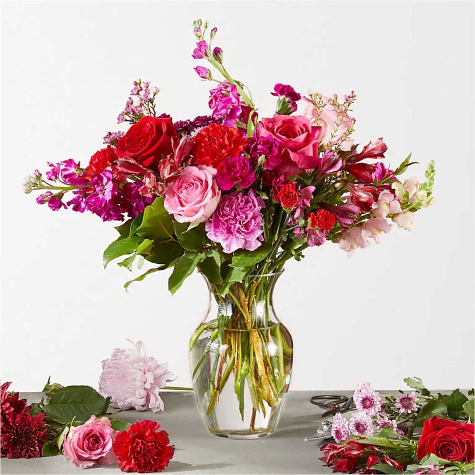 Mixed pink and red flower bouquet in a clear glass vase