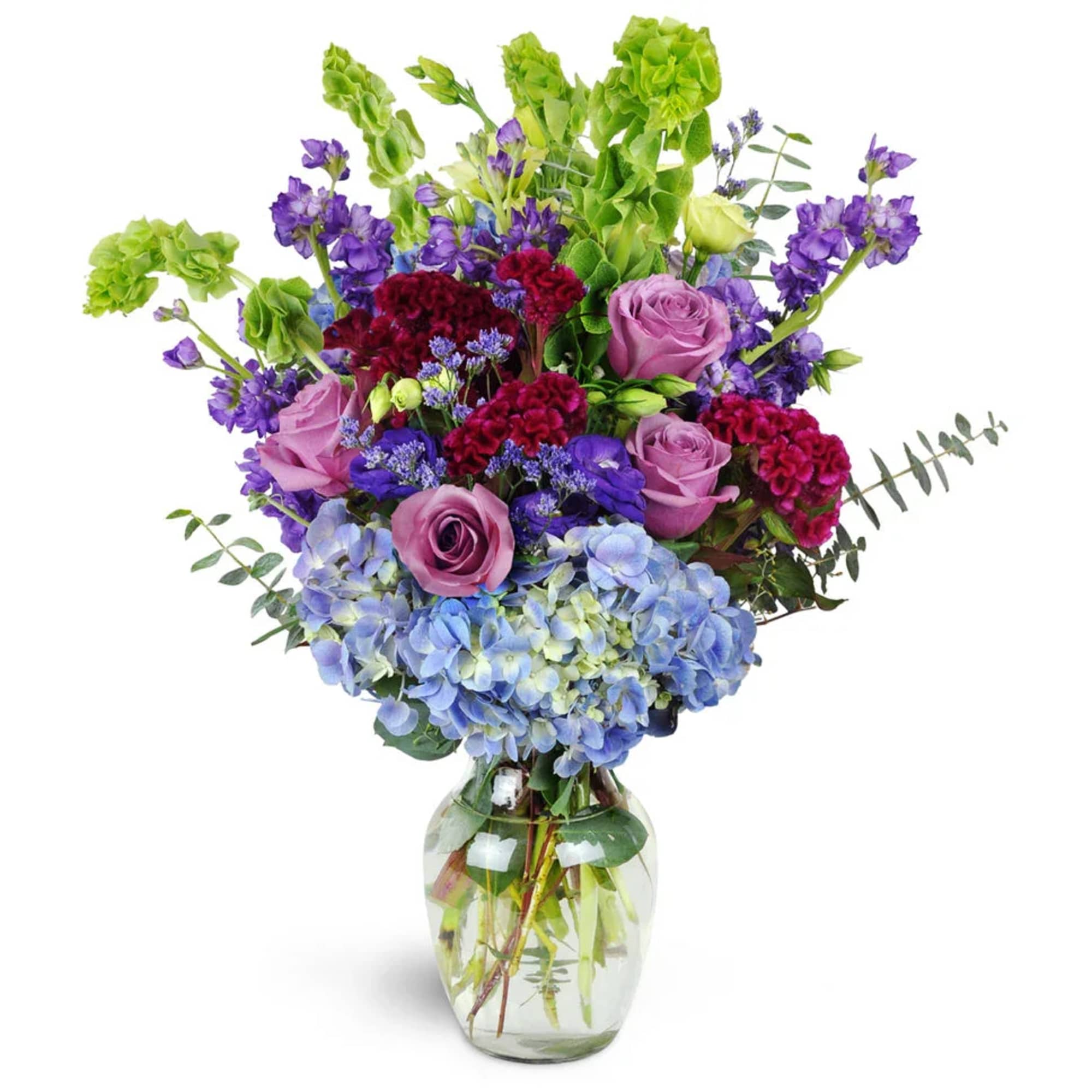 Mixed bouquet of purple, pink, and blue flowers in a glass vase