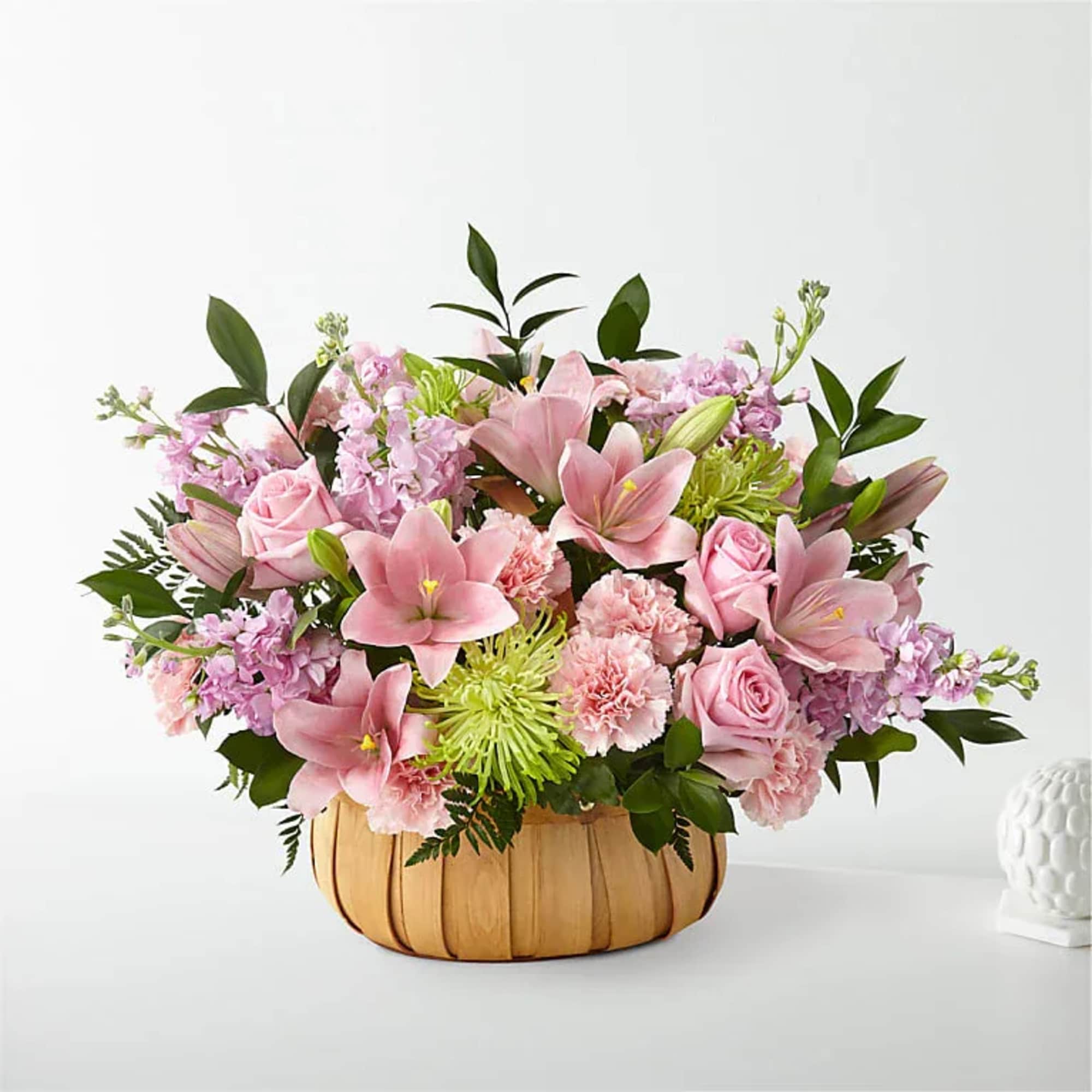Pink lilies and roses in a pumpkin-shaped basket