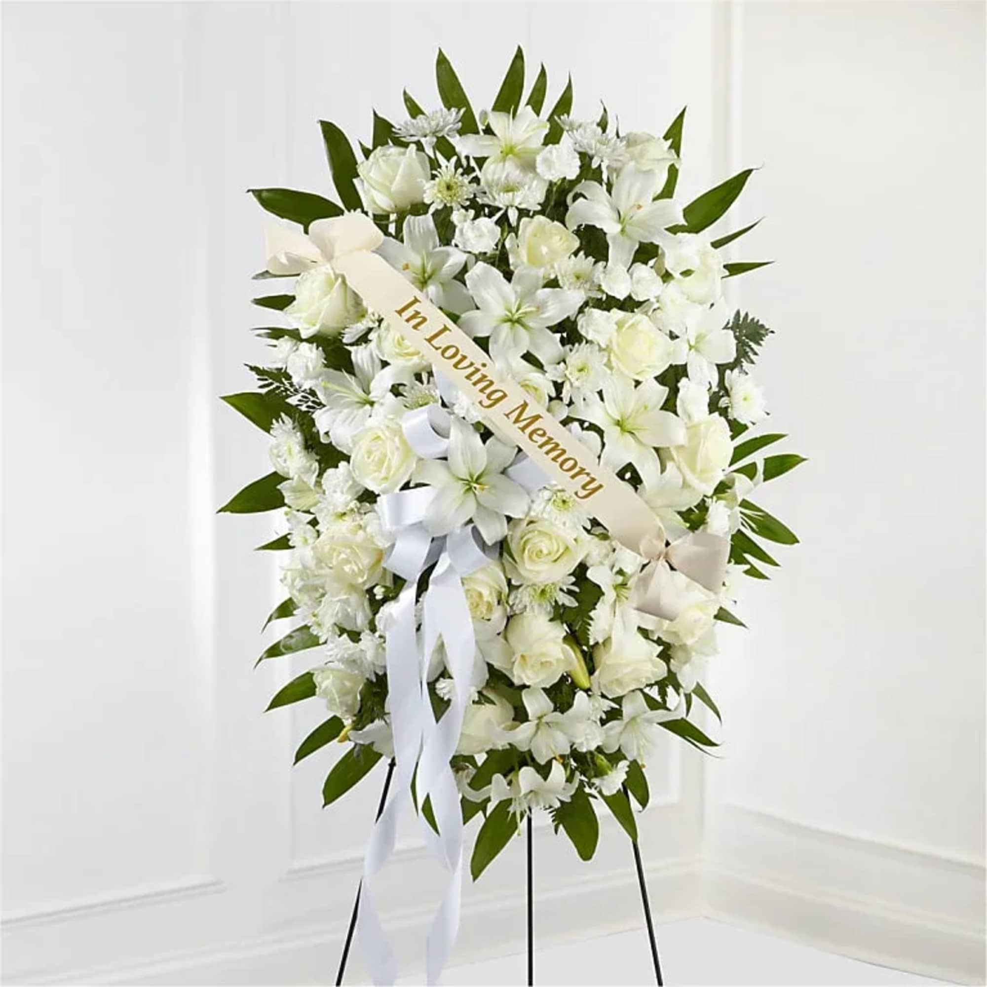 White sympathy standing spray with ribbon on an easel