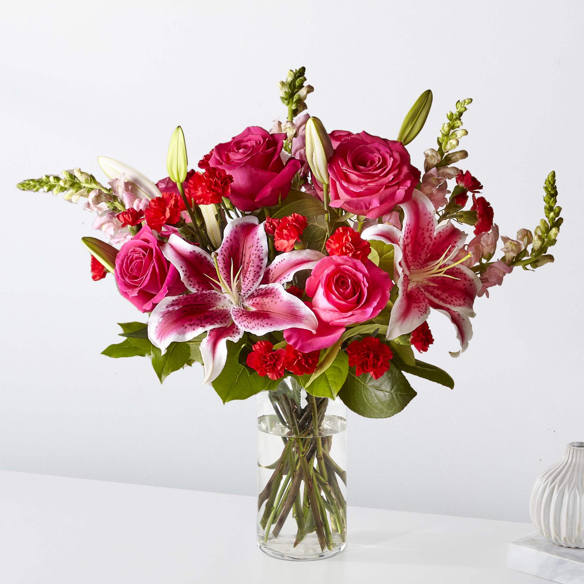 Bouquet of pink roses and lilies in a clear glass vase