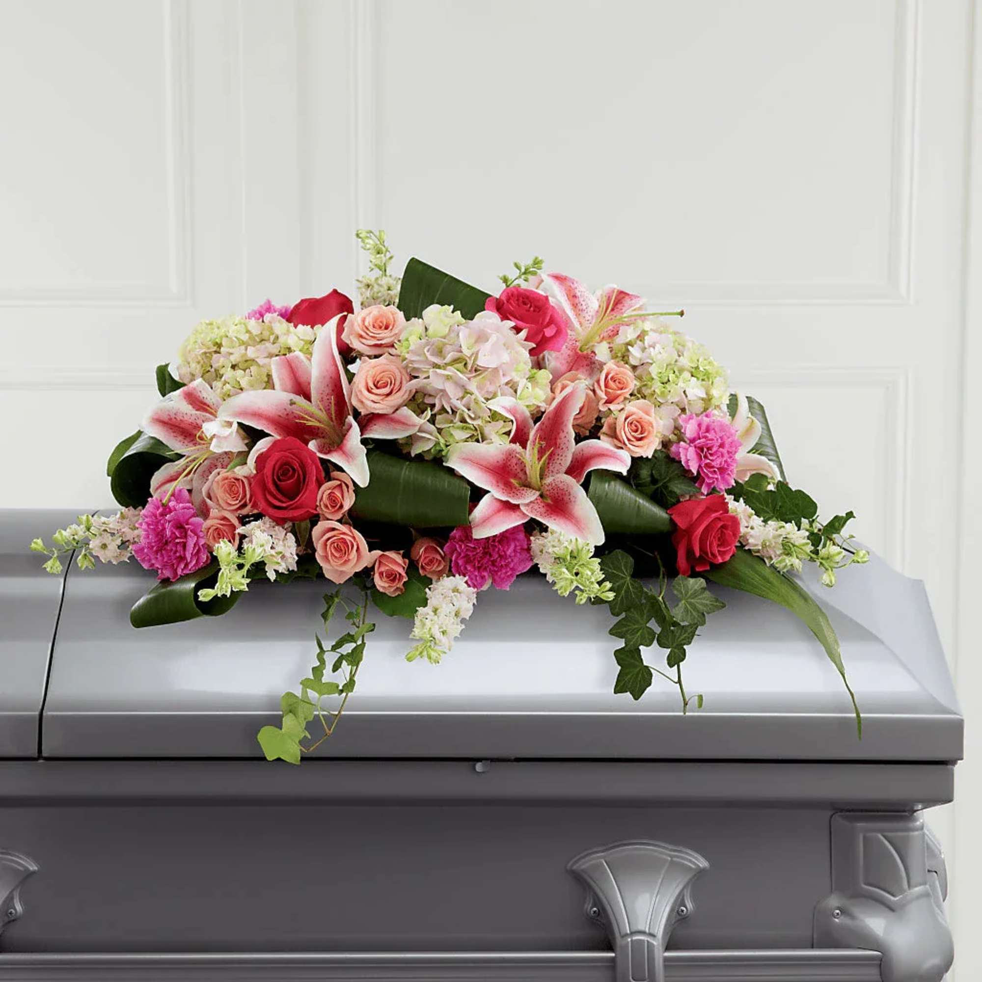 Pink and white floral casket spray with lilies and roses