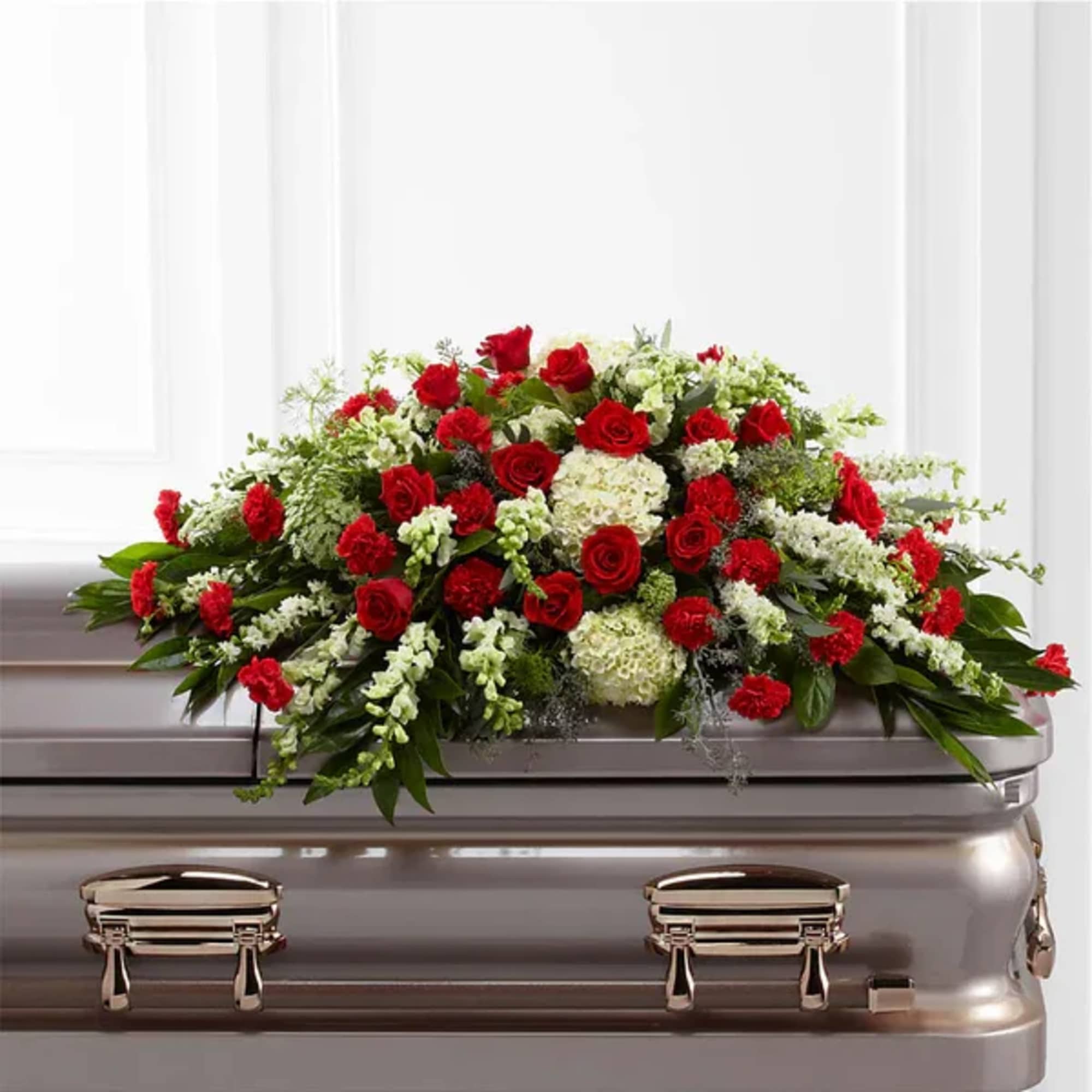 Red and white floral spray on a silver casket