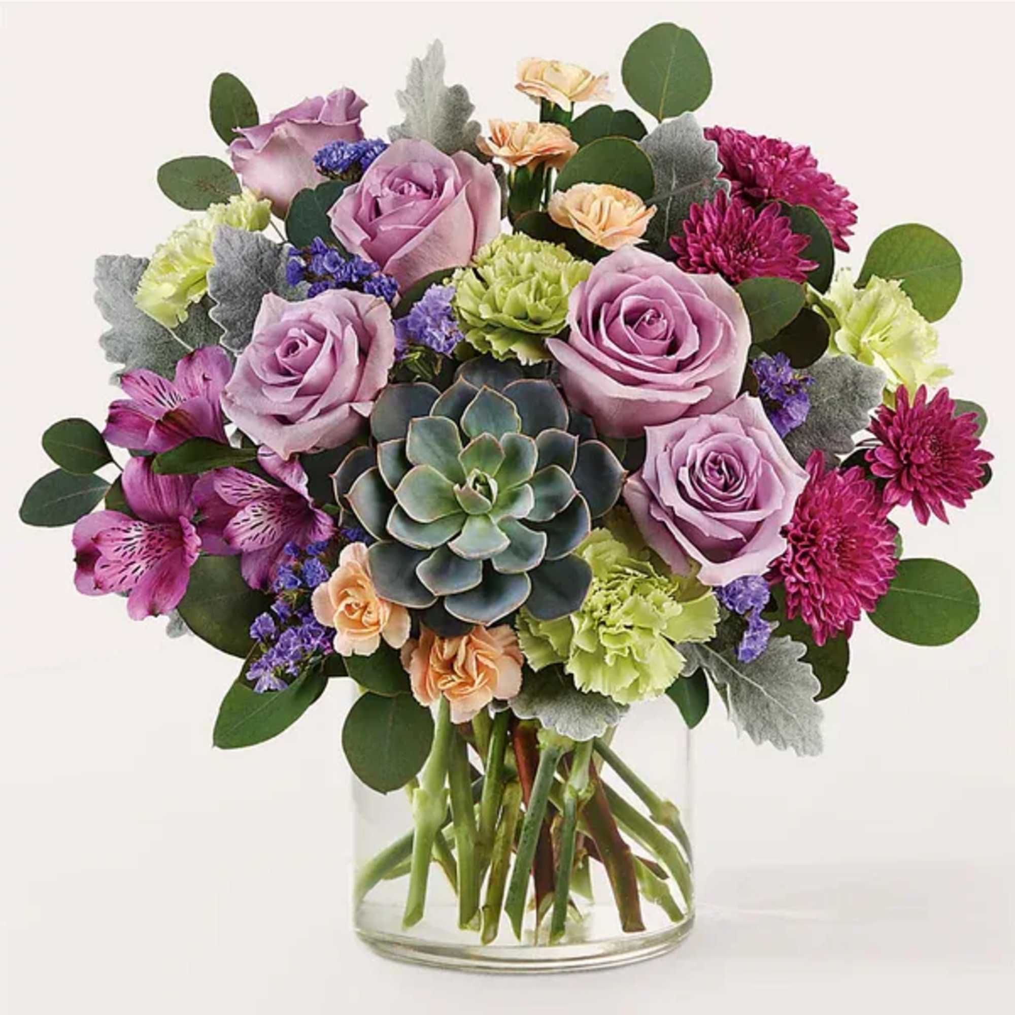 Bouquet of lavender roses and mixed blooms in a clear glass vase
