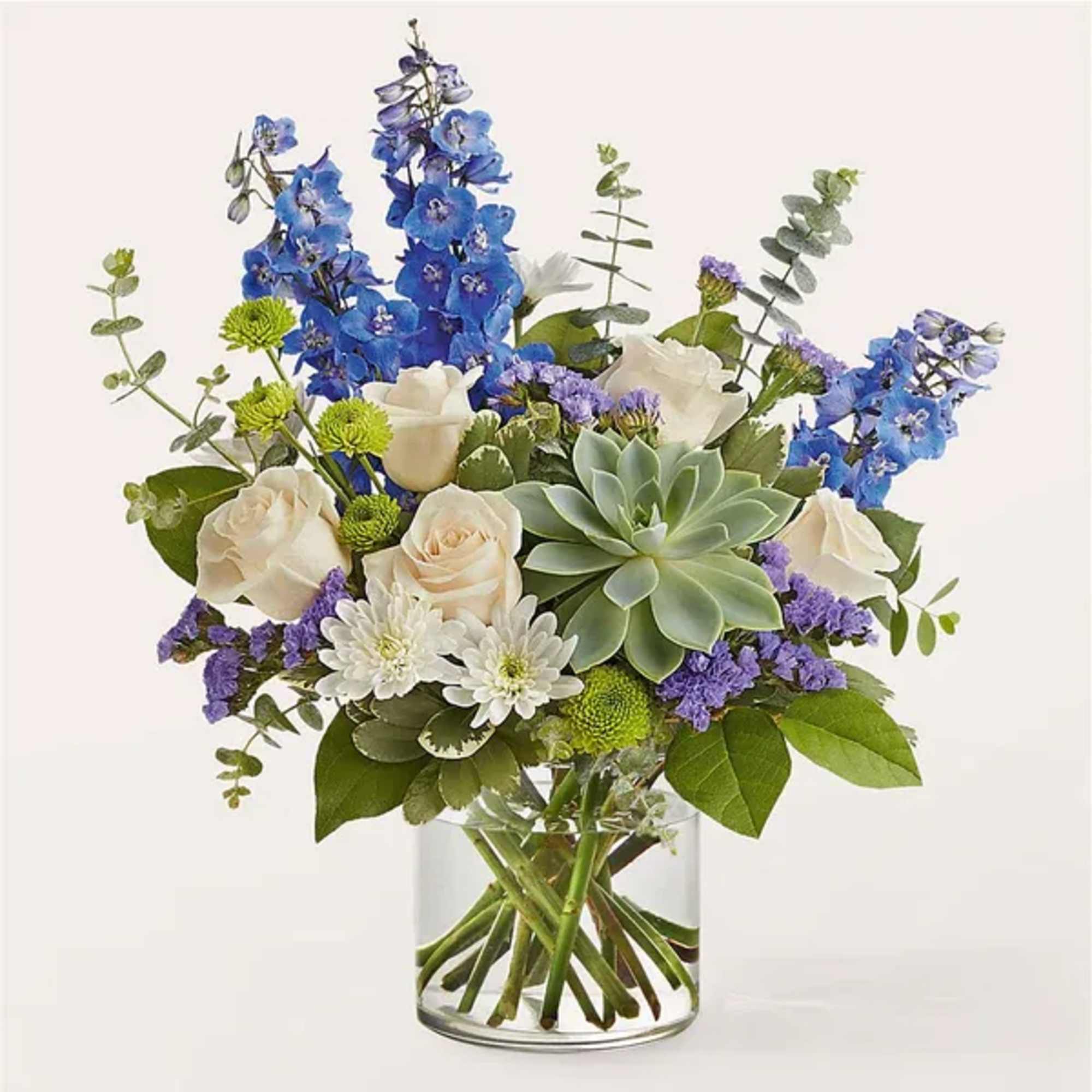 Blue and white flowers arranged in a clear glass vase with a succulent