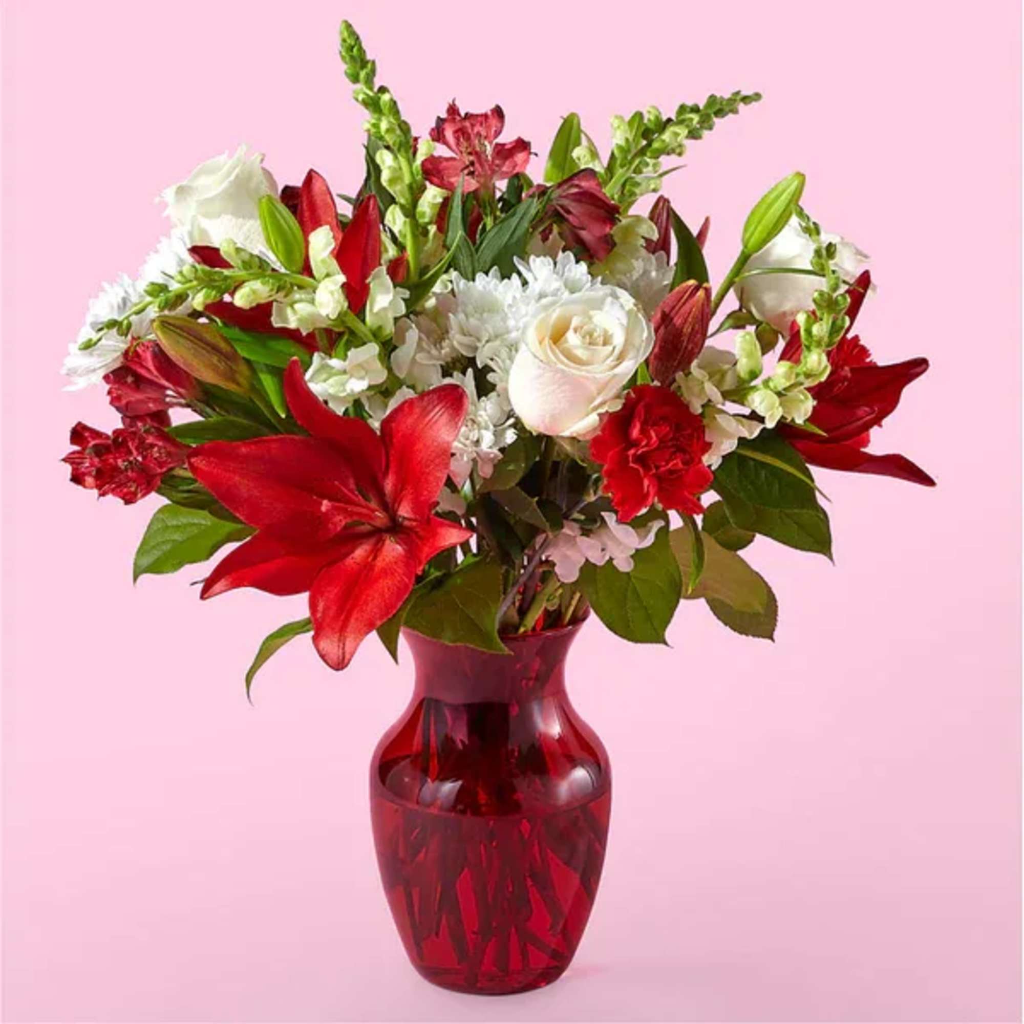 Red and white mixed bouquet in a red glass vase