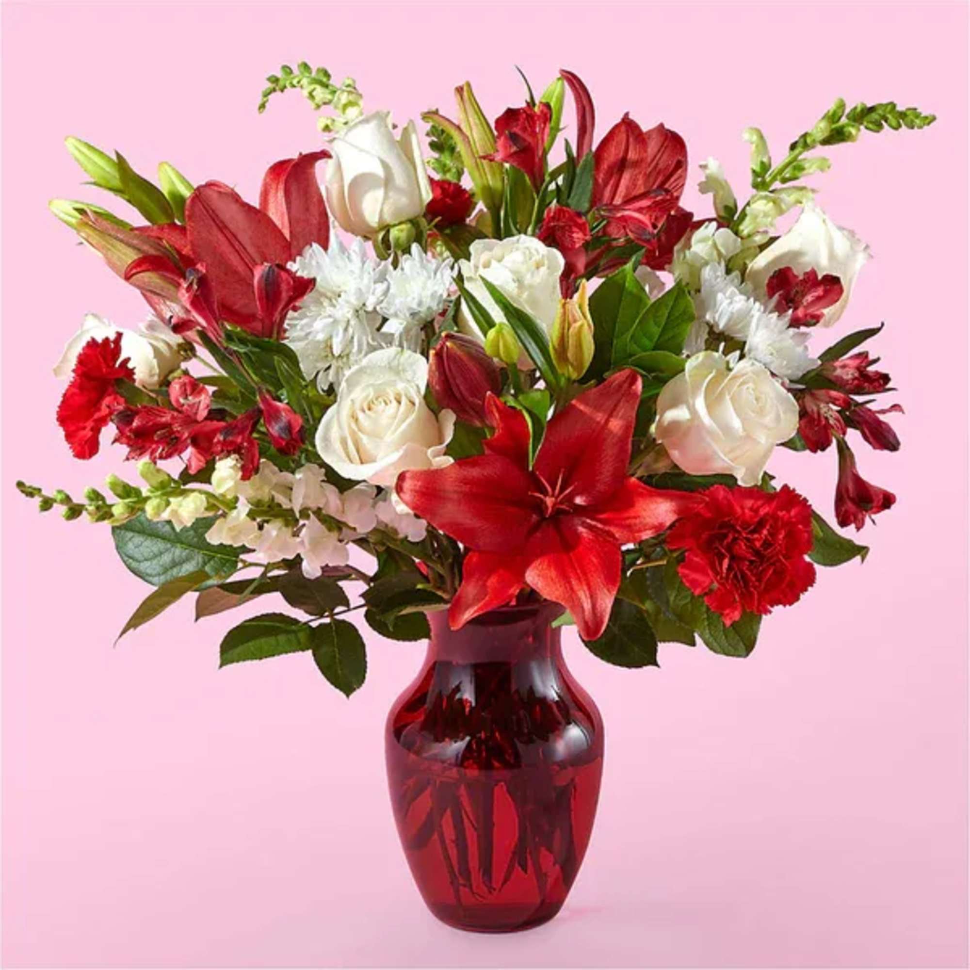 Bouquet of red and white flowers in a red glass vase