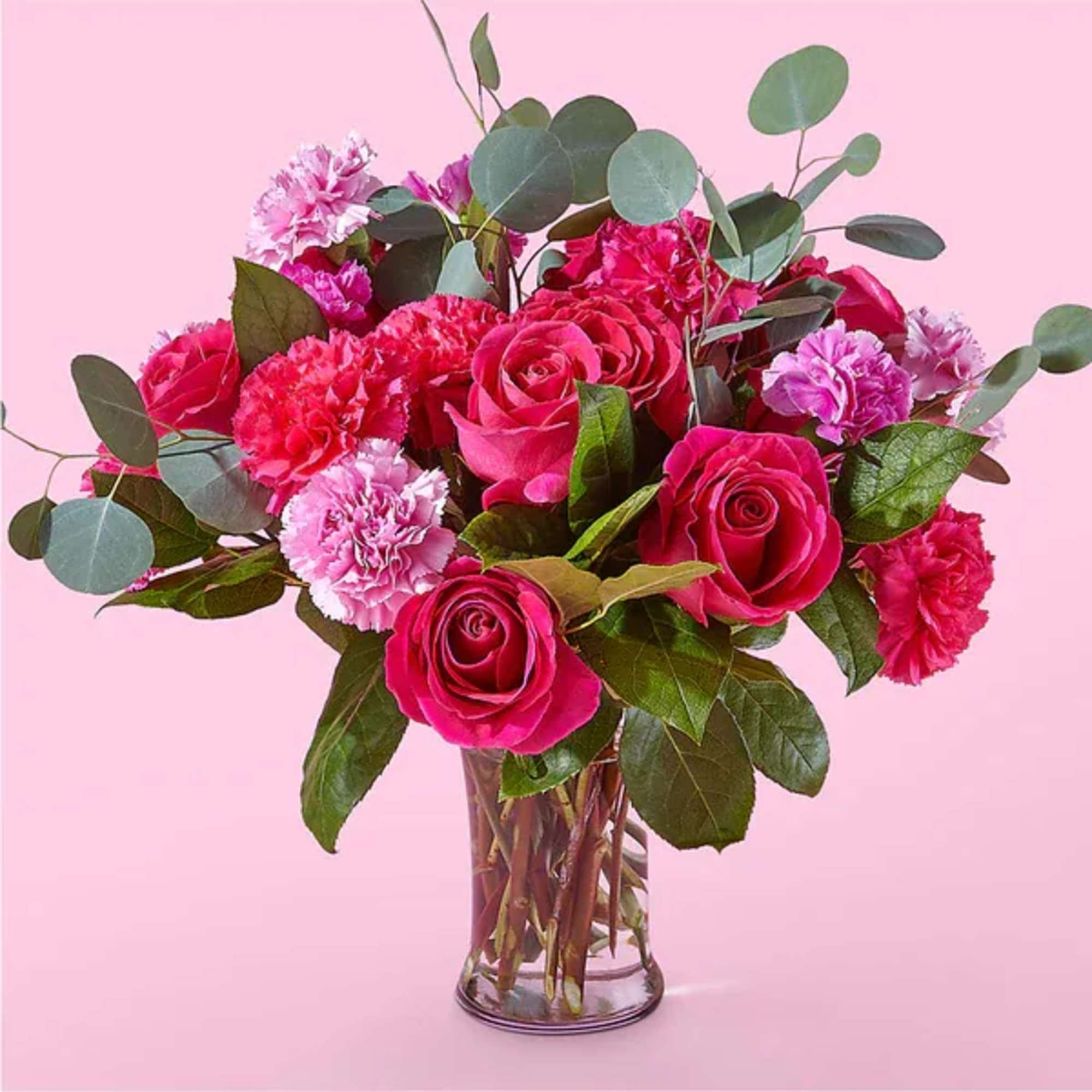 Pink roses and carnations in a clear glass vase