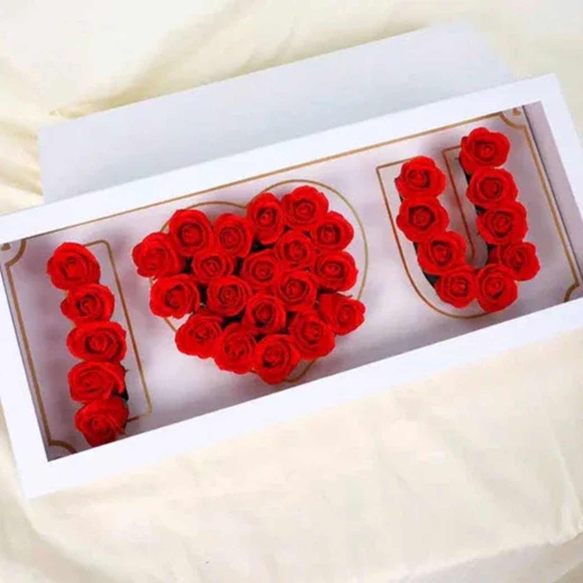 Red roses arranged to spell "I U" on a card