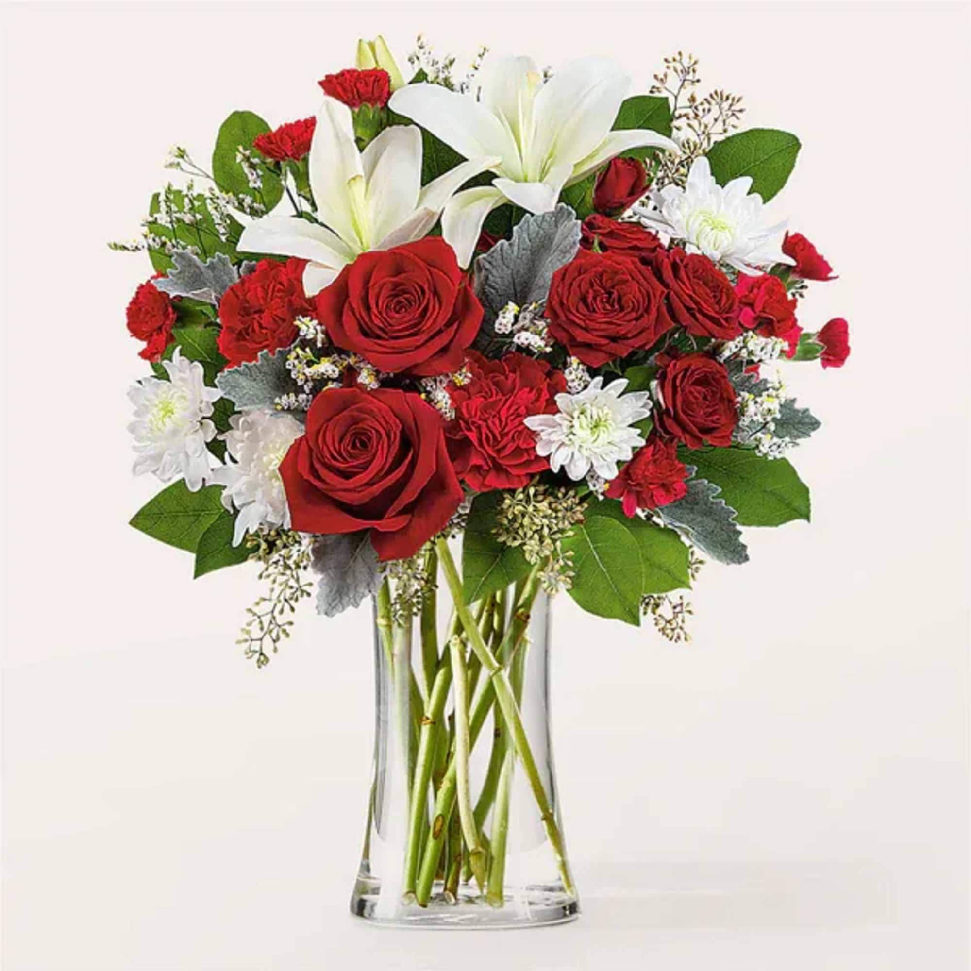 Red roses and white lilies in a clear glass vase