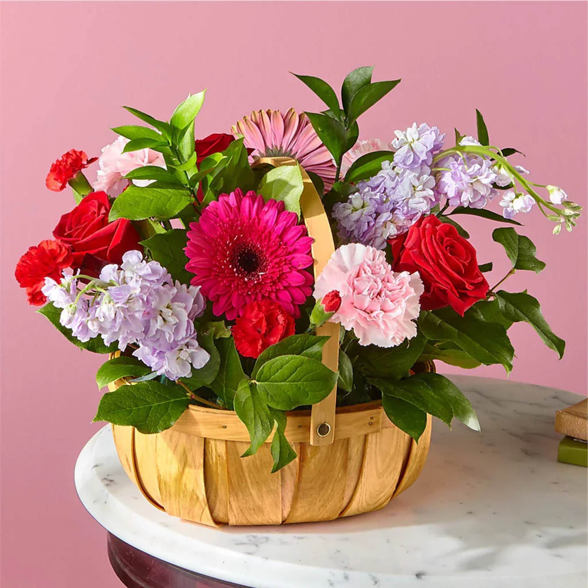 Basket arrangement of red, pink, and lavender flowers