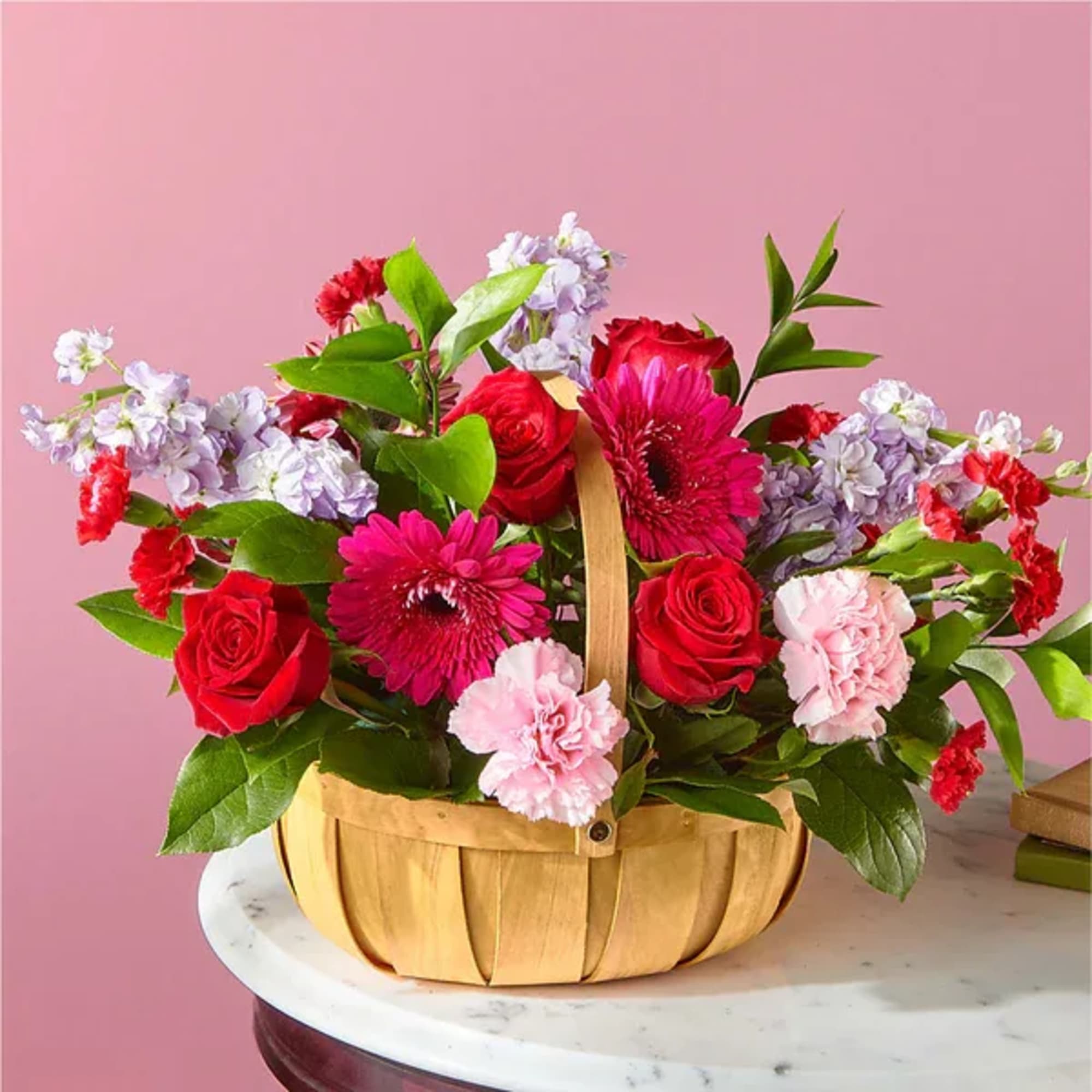 Basket of red roses, pink gerbera daisies, and carnations