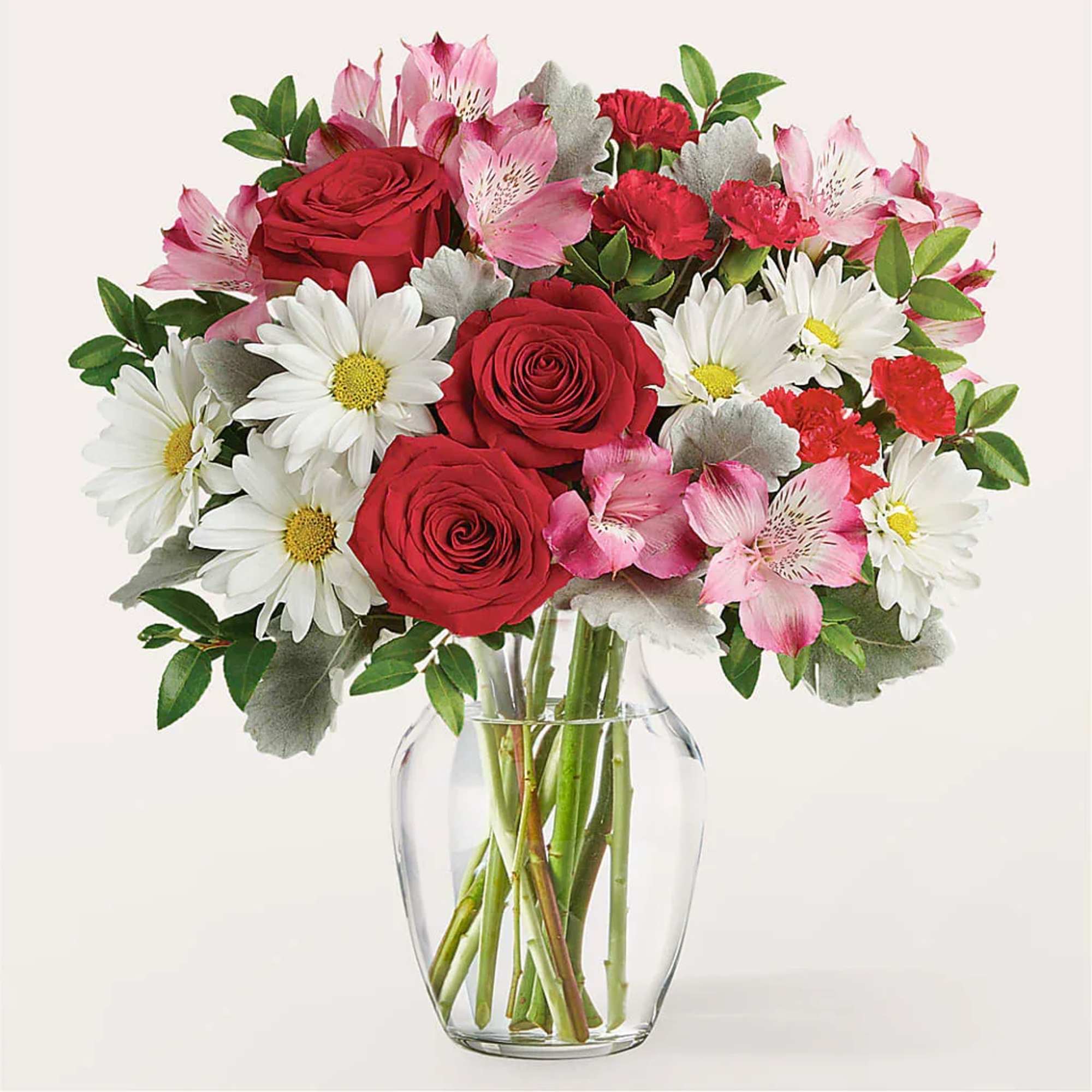 Bouquet of red roses, white daisies, and pink alstroemeria in a glass vase