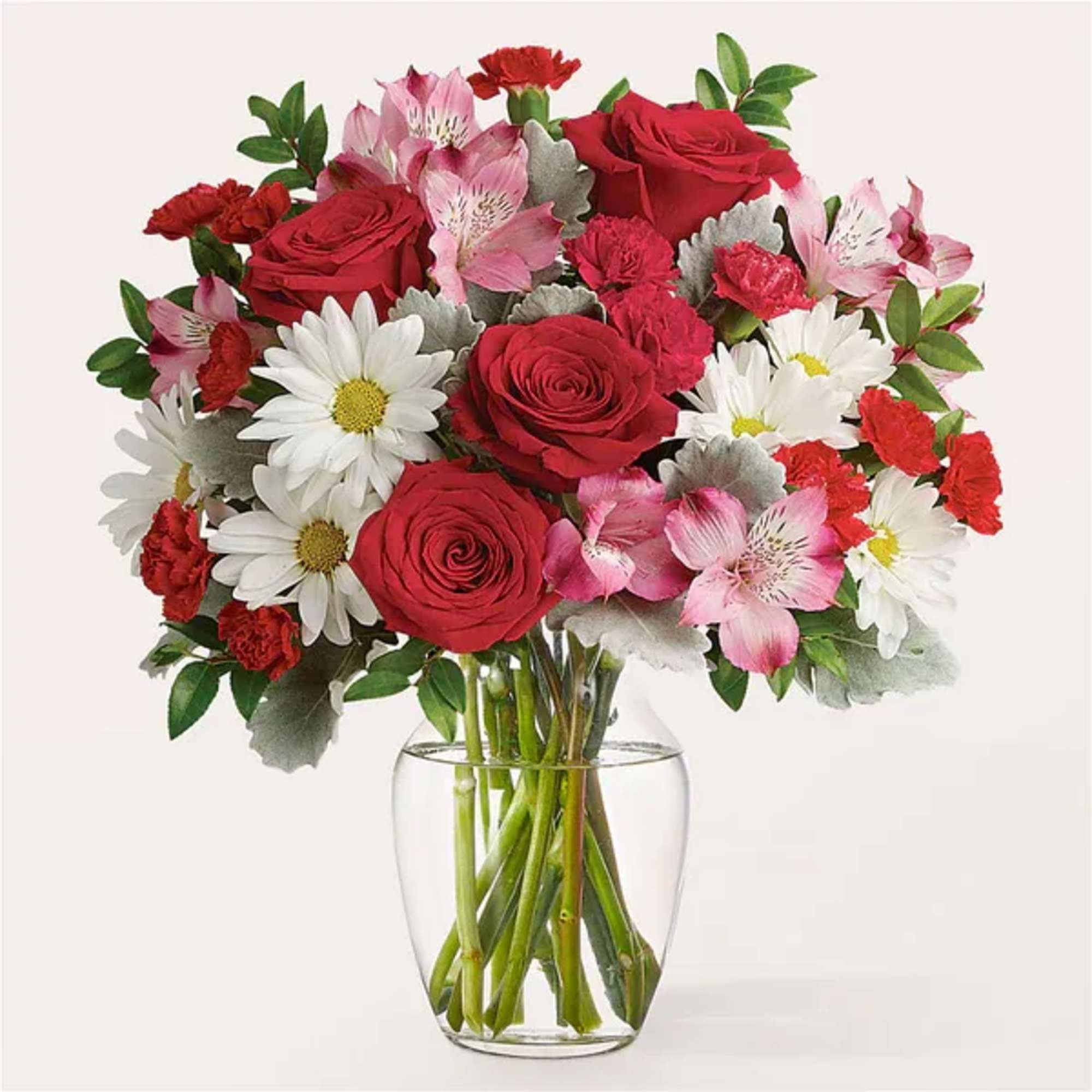Bouquet of red roses, pink alstroemeria, and white daisies in a clear glass vase