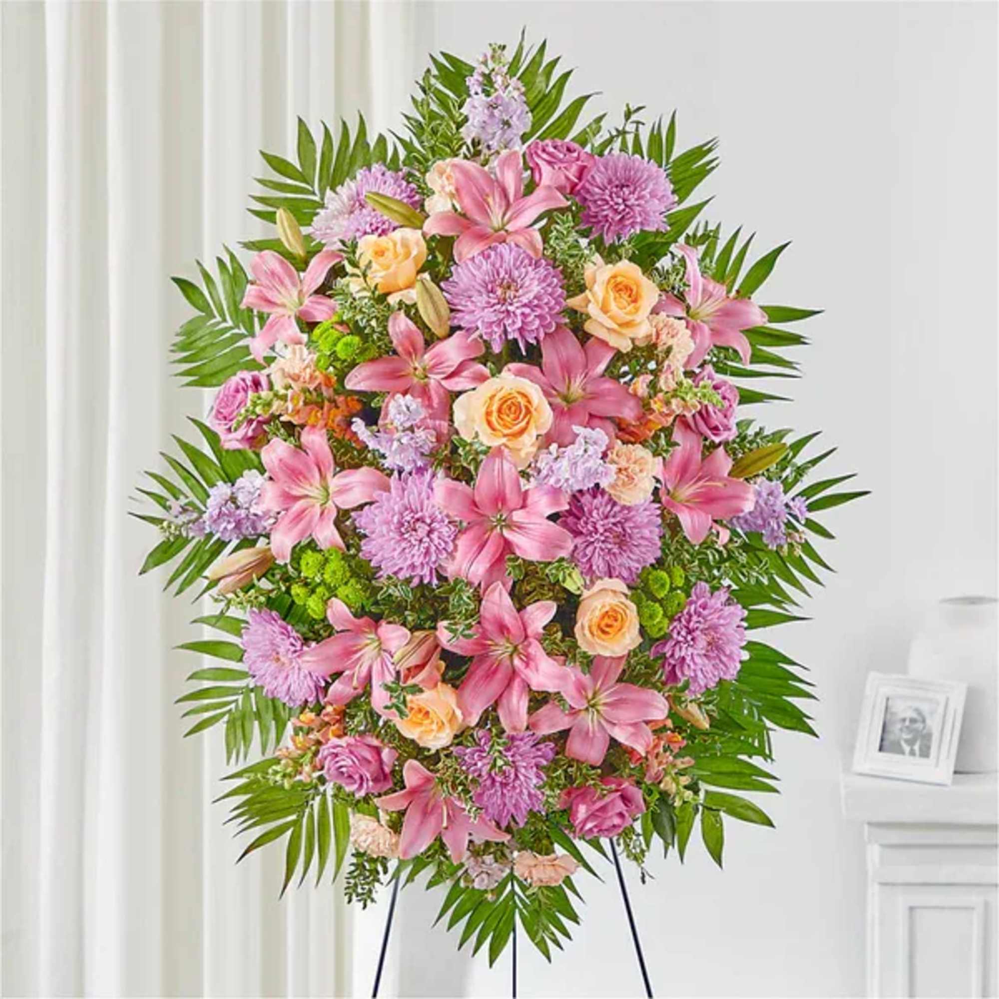 Large pink and peach floral standing spray on an easel
