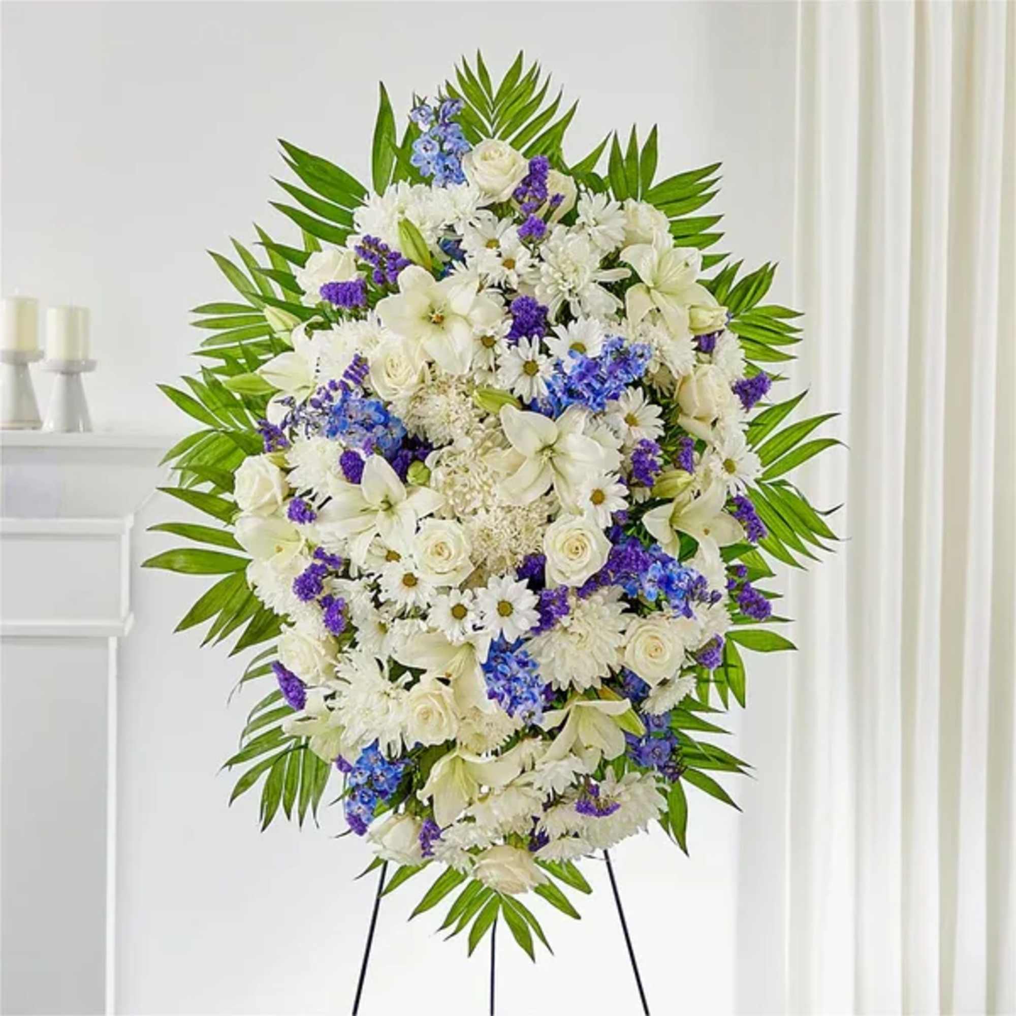 Standing funeral spray of white and purple flowers on an easel