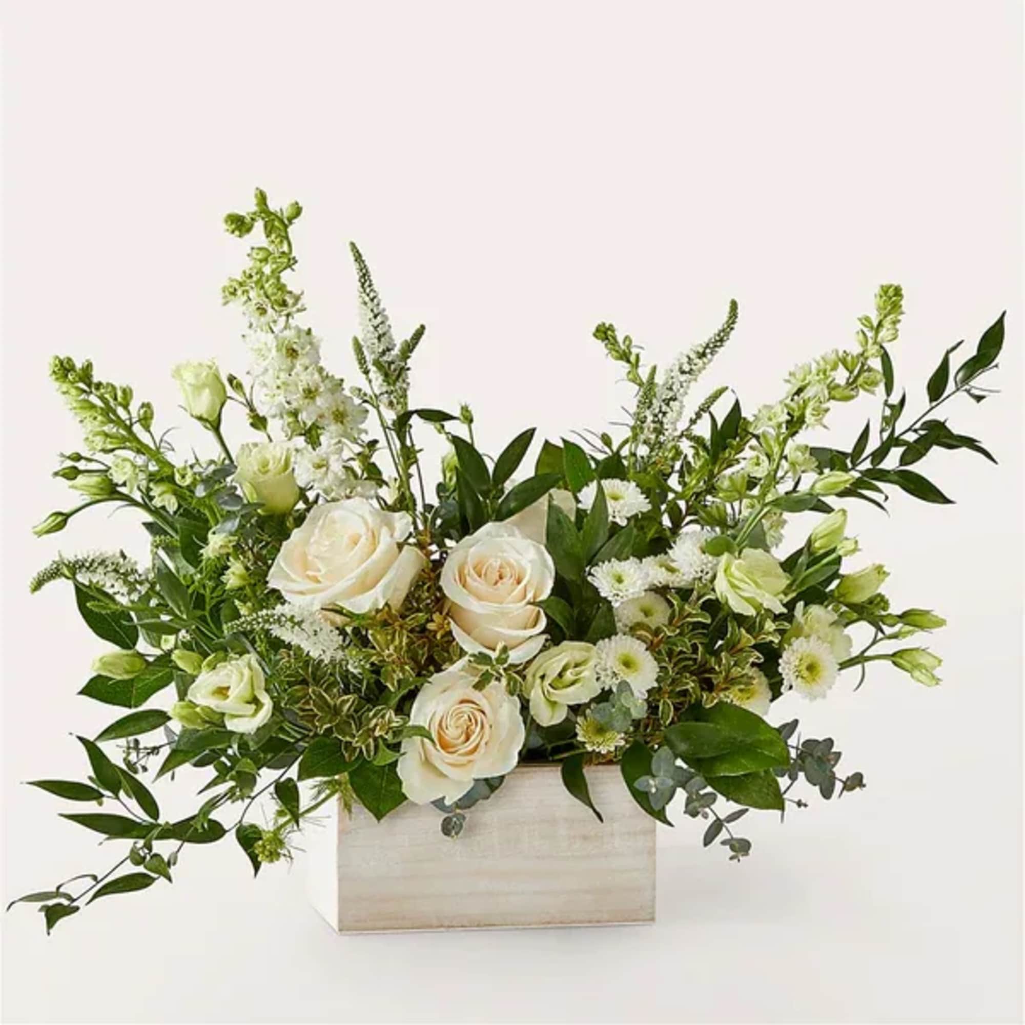 White roses and green-white flowers in a rectangular wooden box