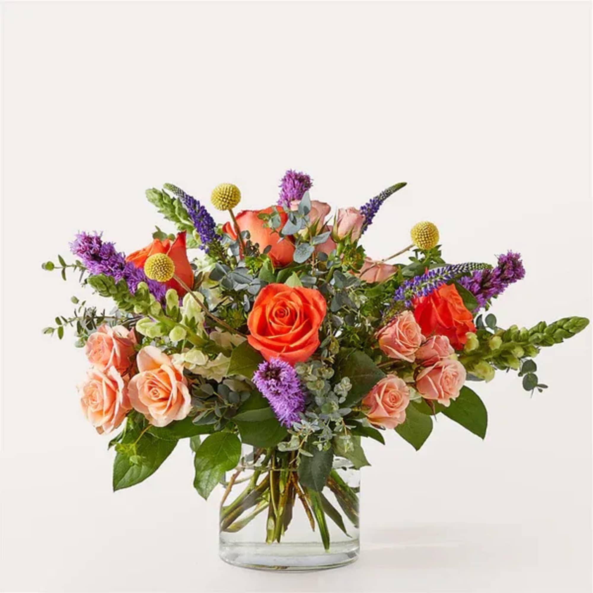 Bouquet of orange and peach roses in a clear glass vase