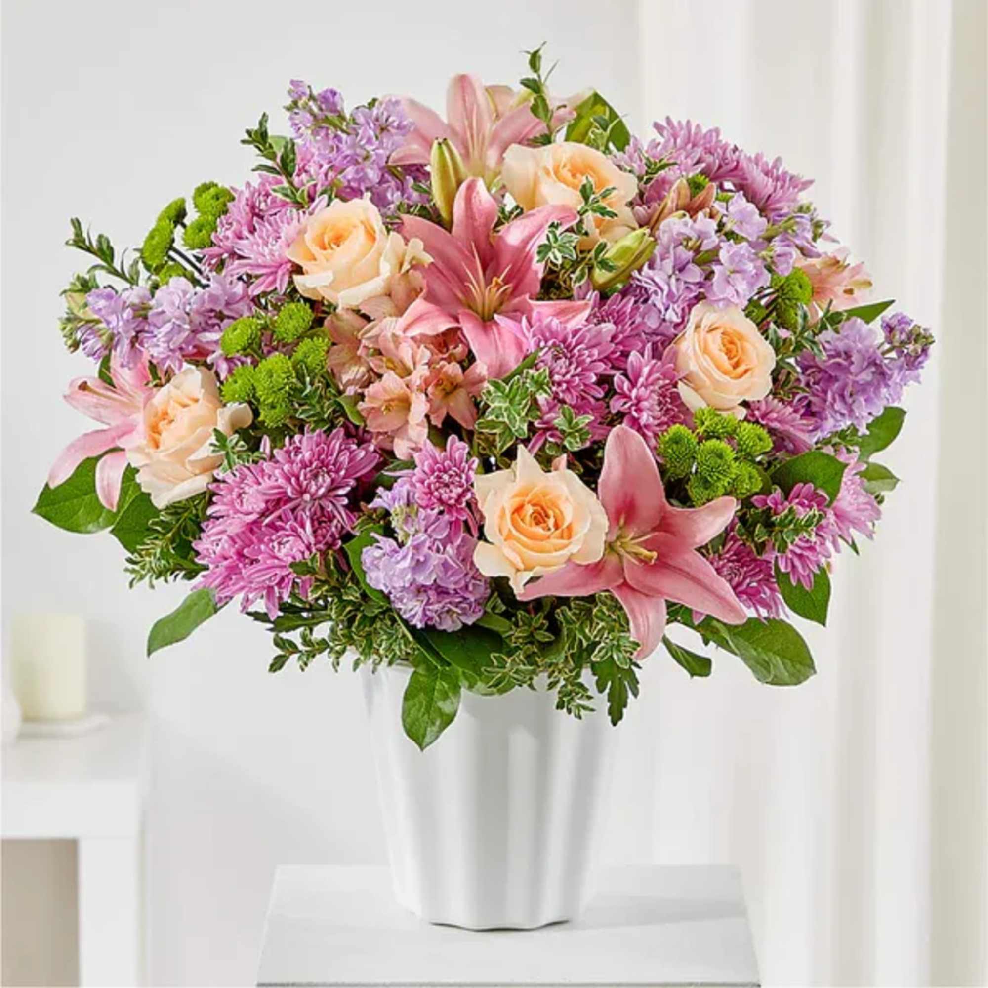 Pink lilies and peach roses in a white vase
