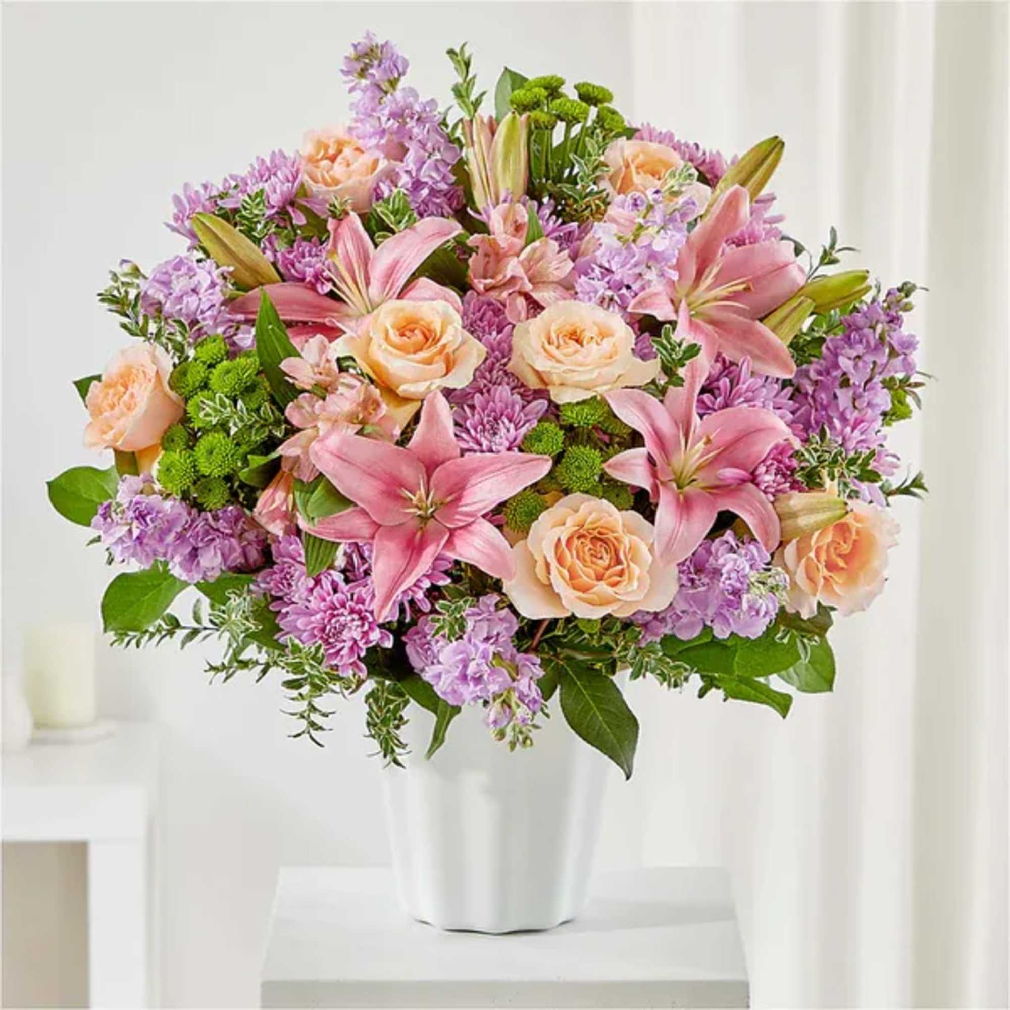 Pink lilies and peach roses in a white vase