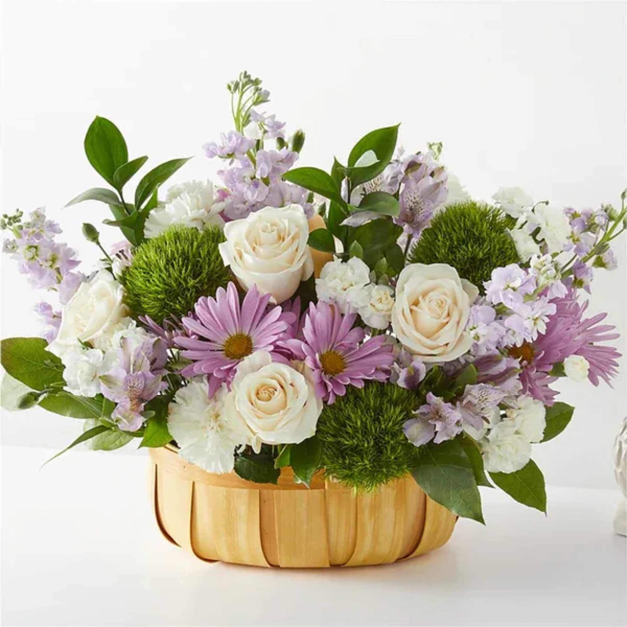 Lavender daisies and white roses in a wooden basket