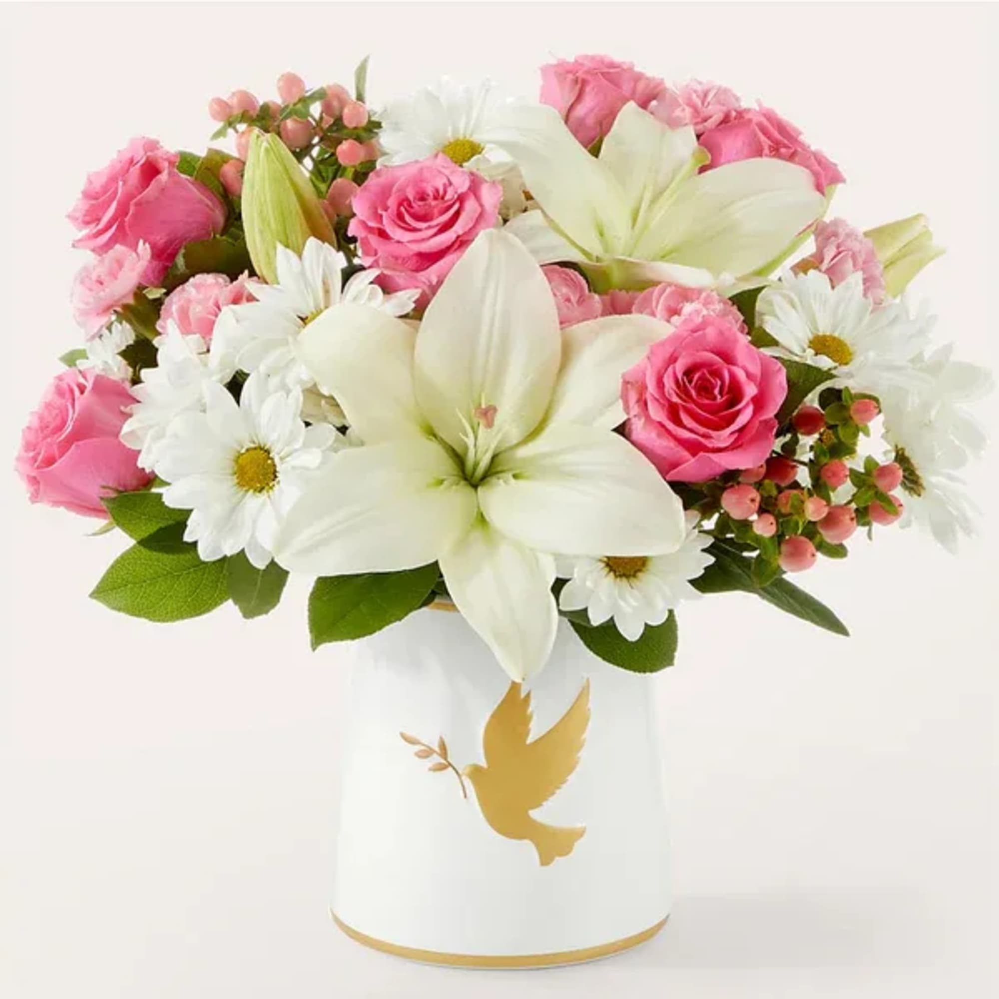 Pink roses and white lilies in a white vase with a gold dove design