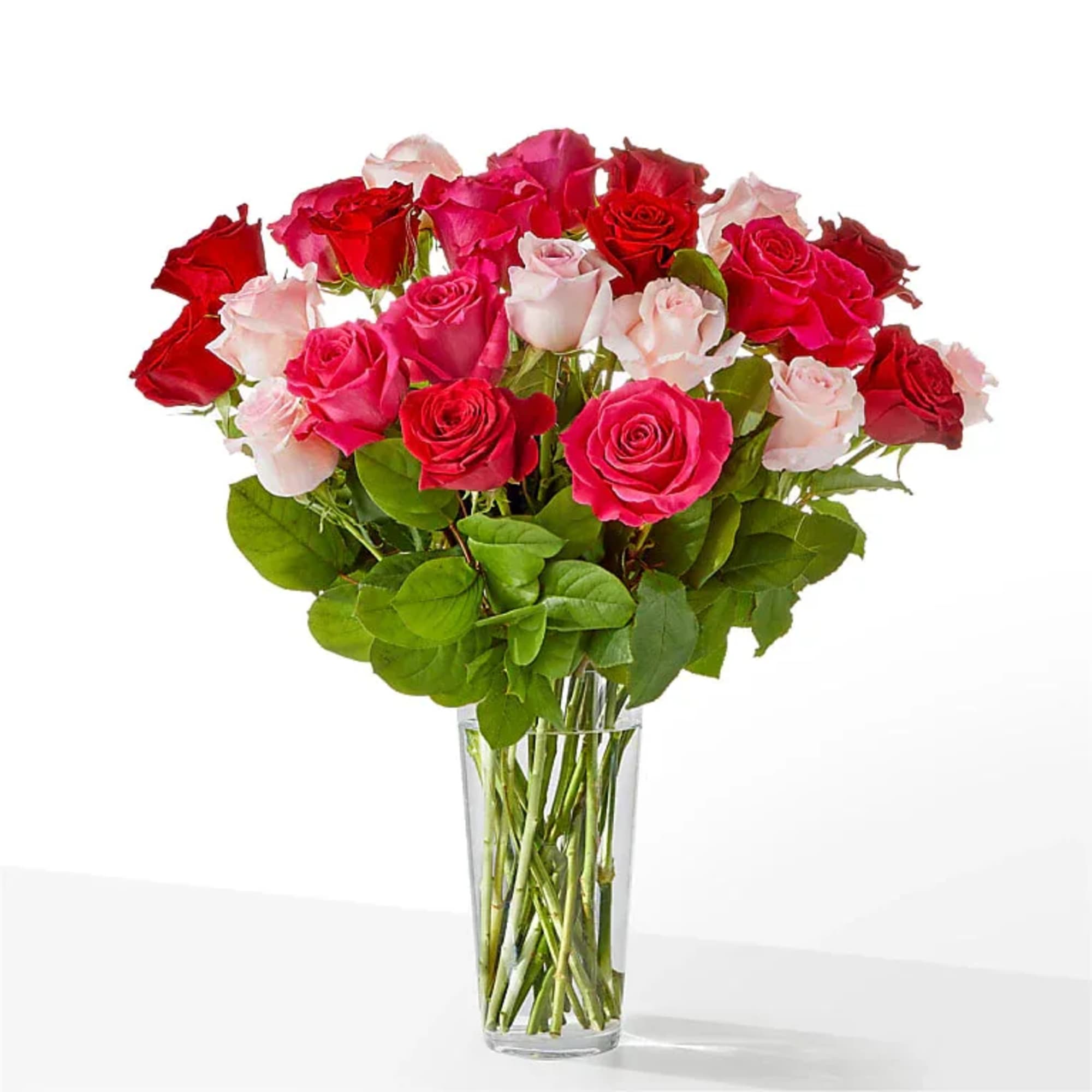 Bouquet of red, pink, and white roses in a clear glass vase