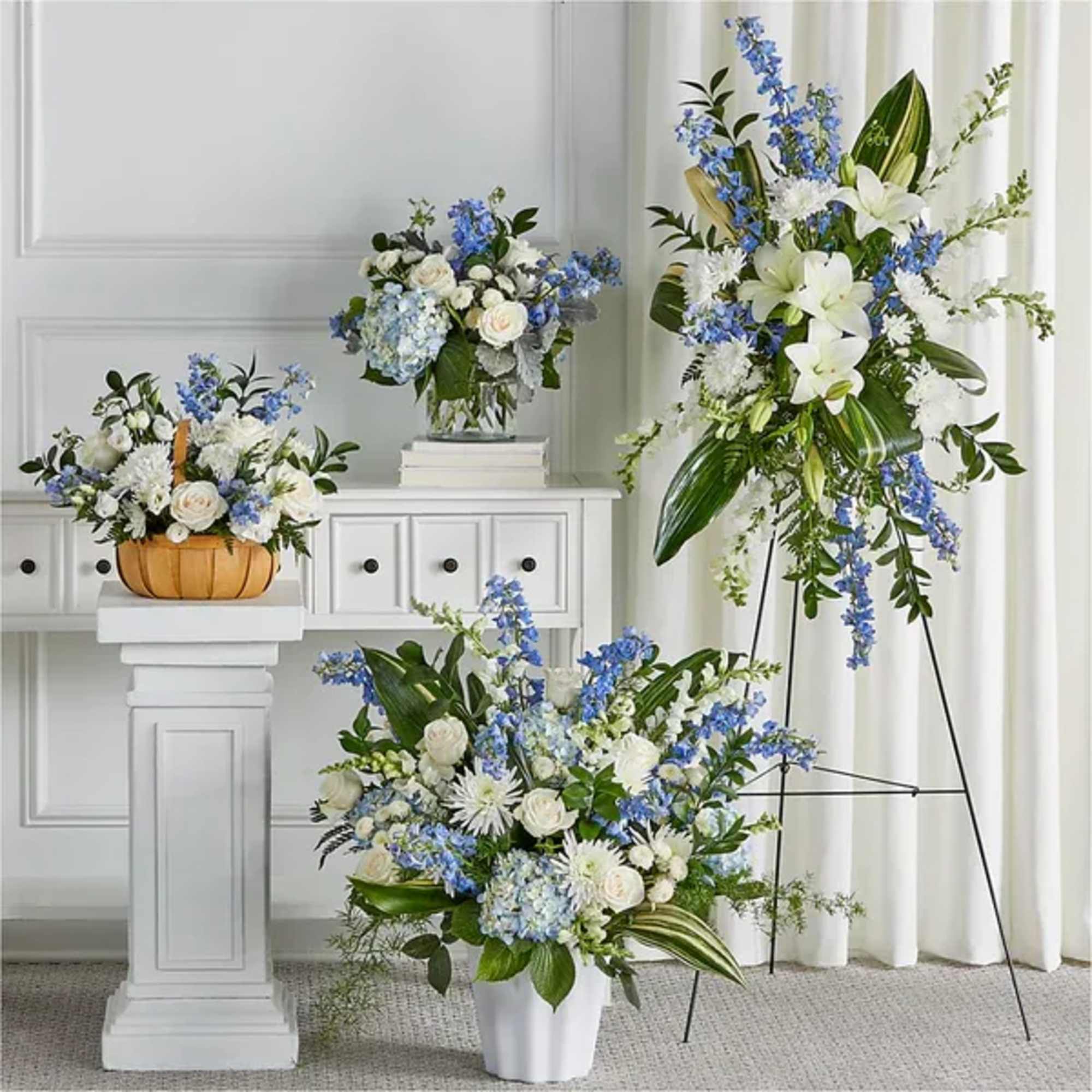 Blue and white floral arrangements in vases and a basket
