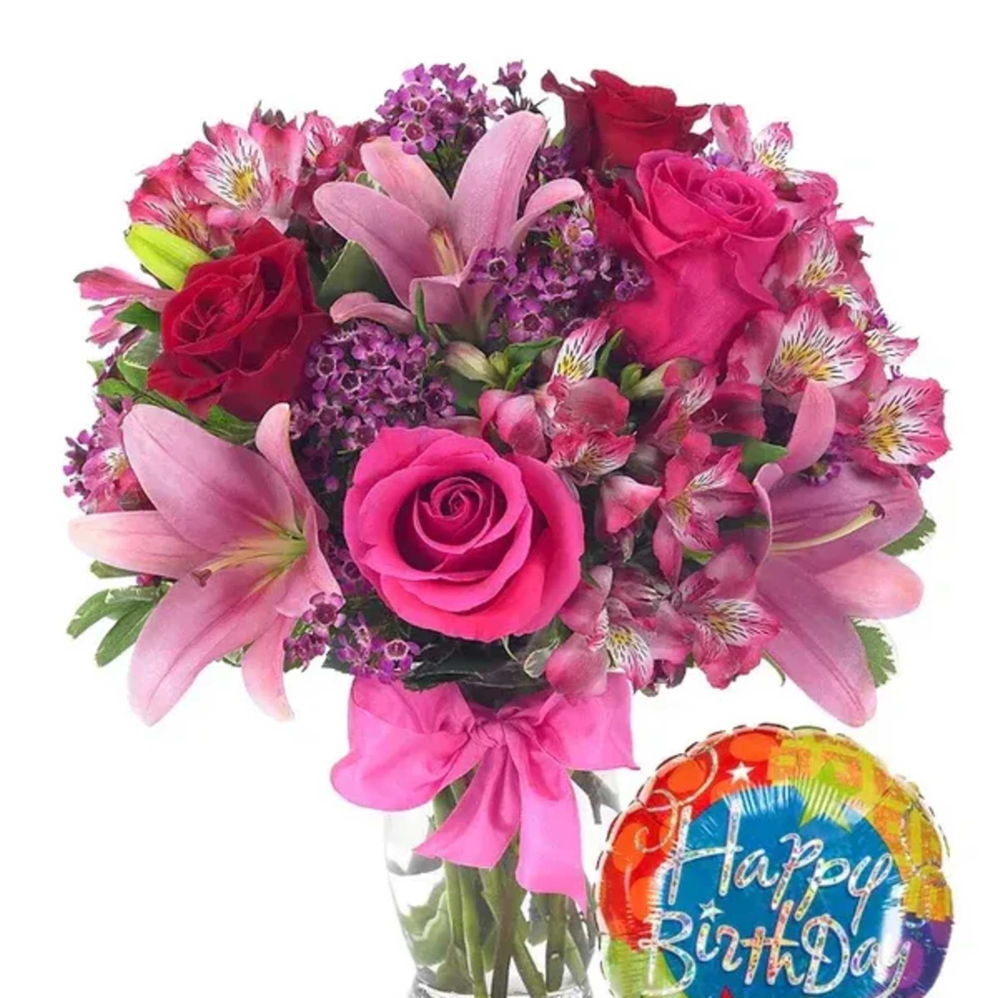 Pink and red flower bouquet in a glass vase with a birthday balloon