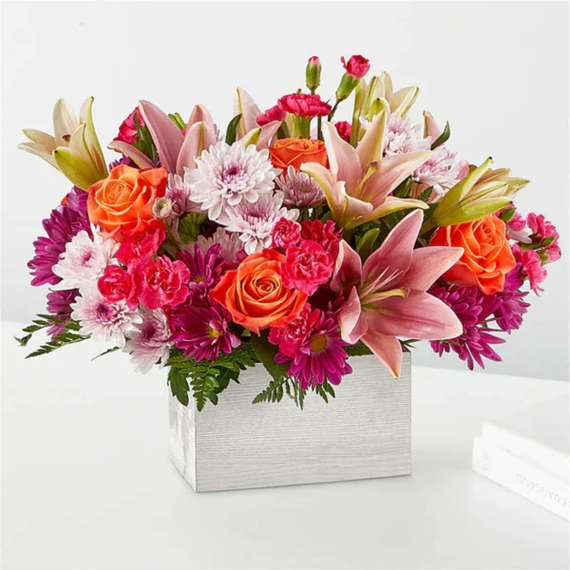 Mixed bouquet of pink lilies, orange roses, and chrysanthemums in a white box