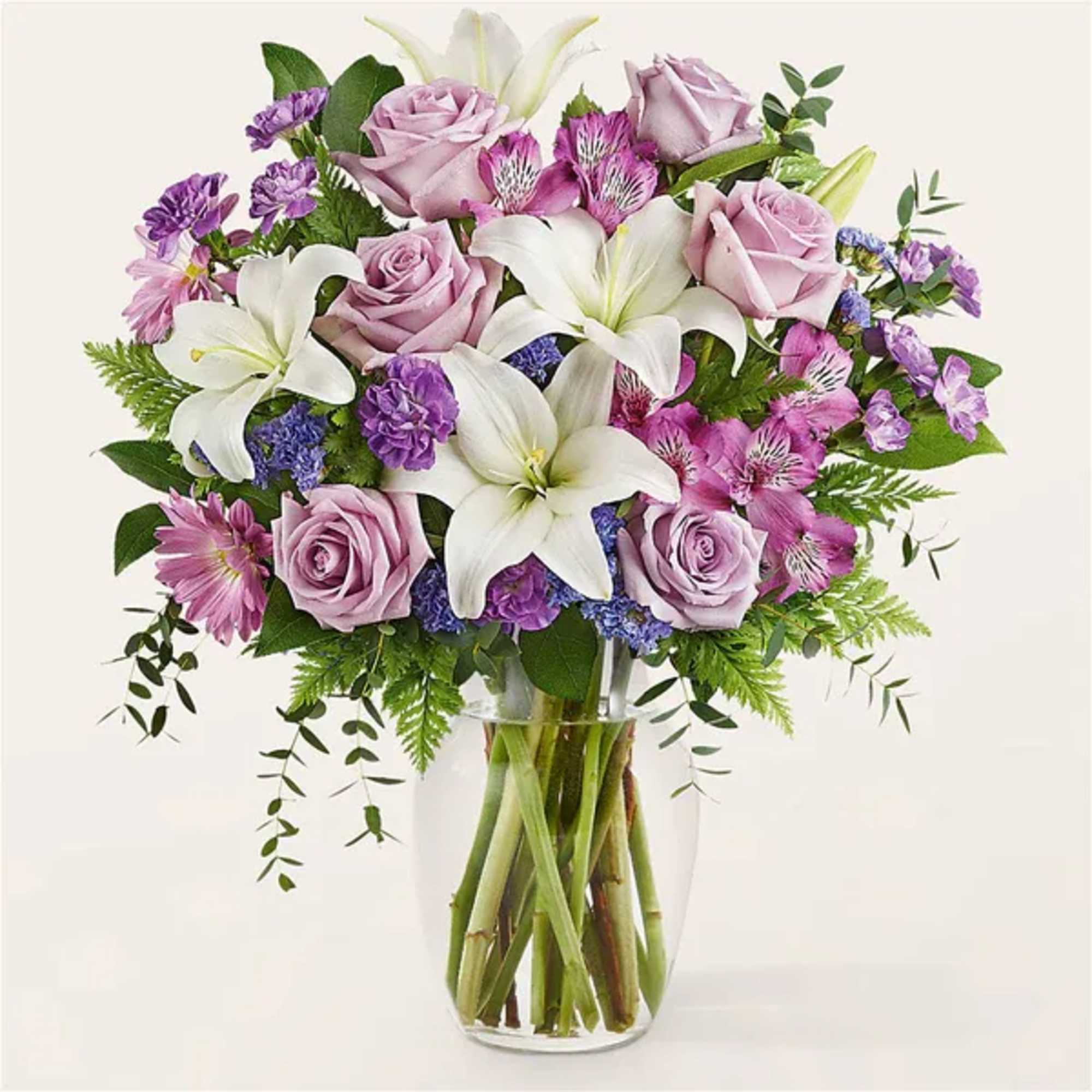 Bouquet of pink roses and white lilies in a clear glass vase