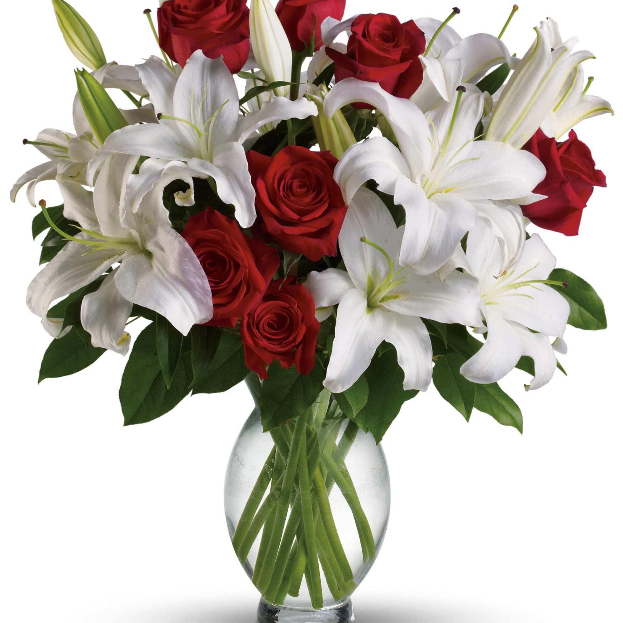 Red roses and white lilies arranged in a clear glass vase
