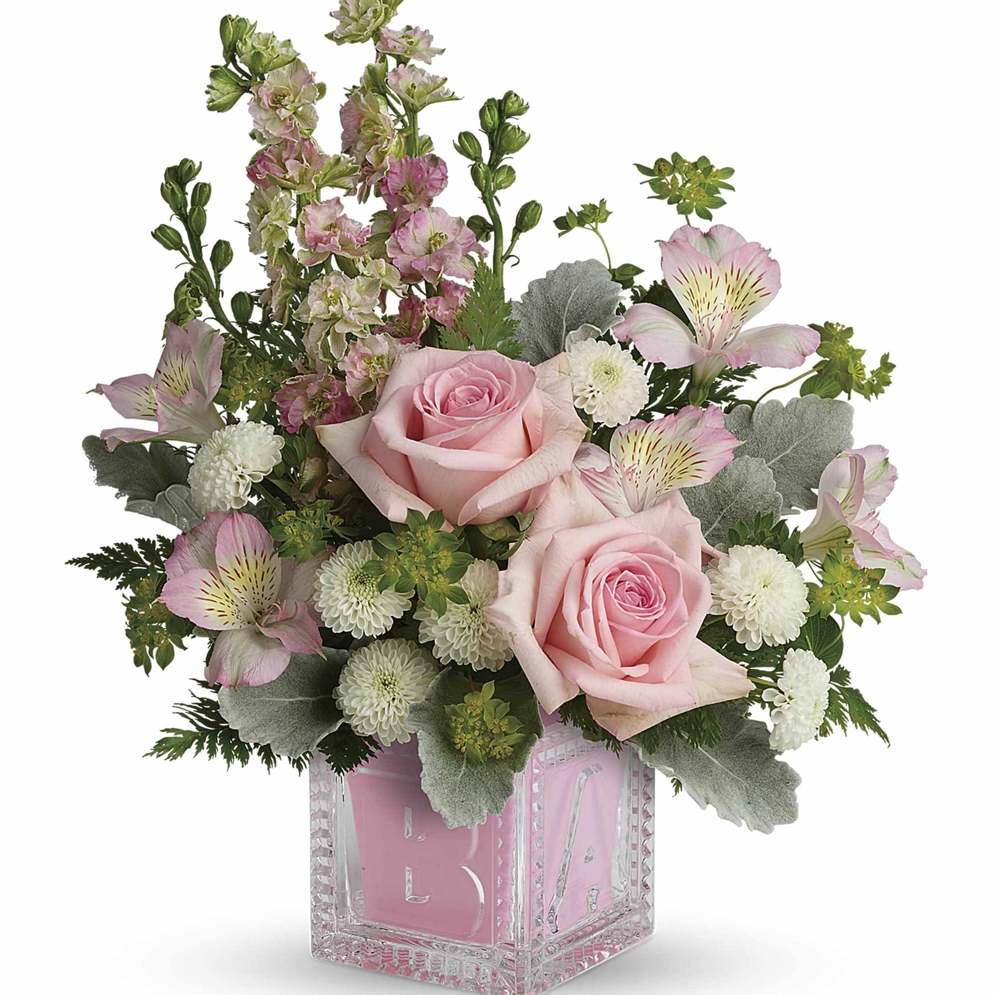 Pink roses and mixed blooms arranged in a clear glass cube vase