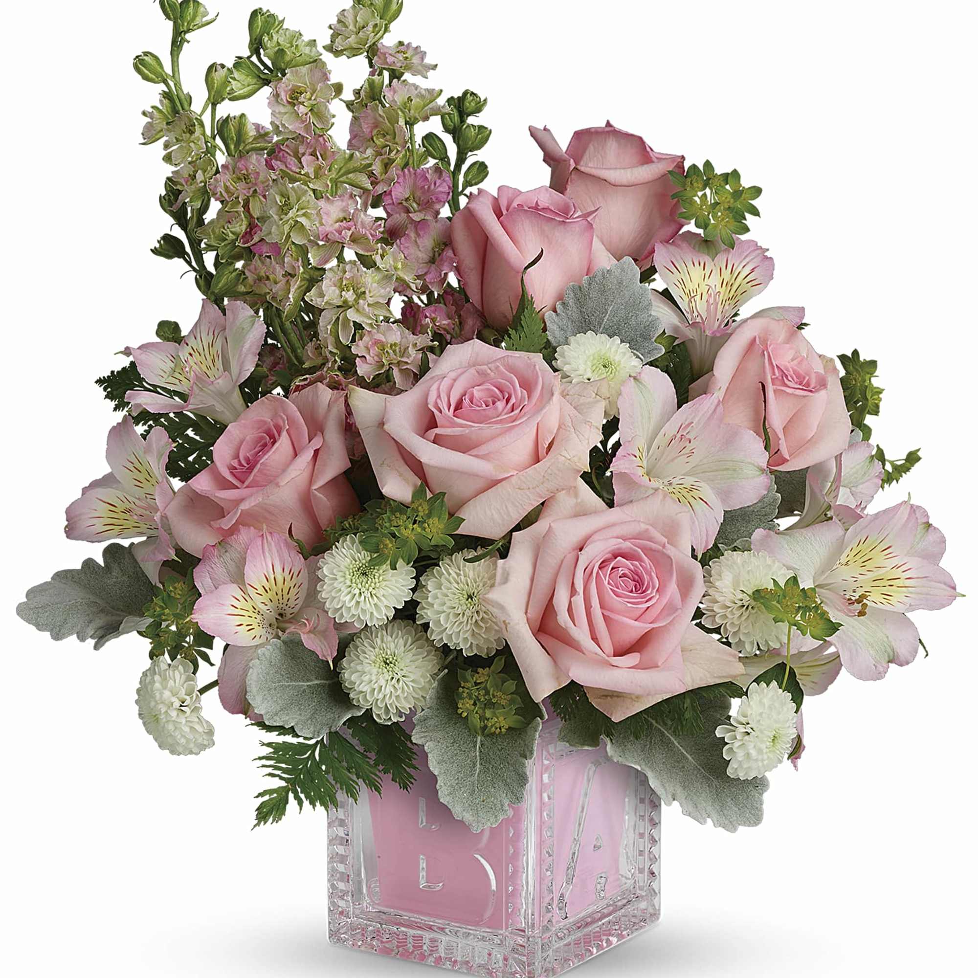 Pink roses and mixed blooms arranged in a clear glass cube vase