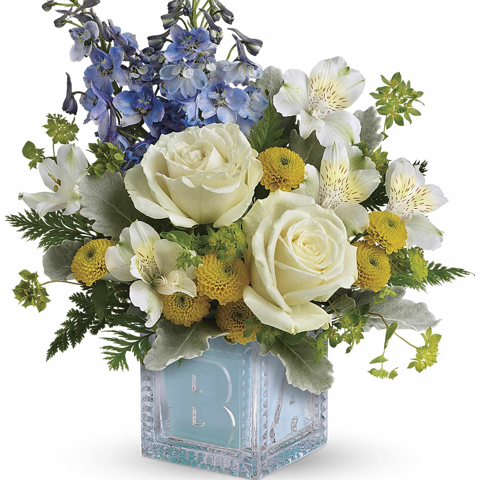 Bouquet of white roses, blue flowers, and yellow blooms in a glass cube vase