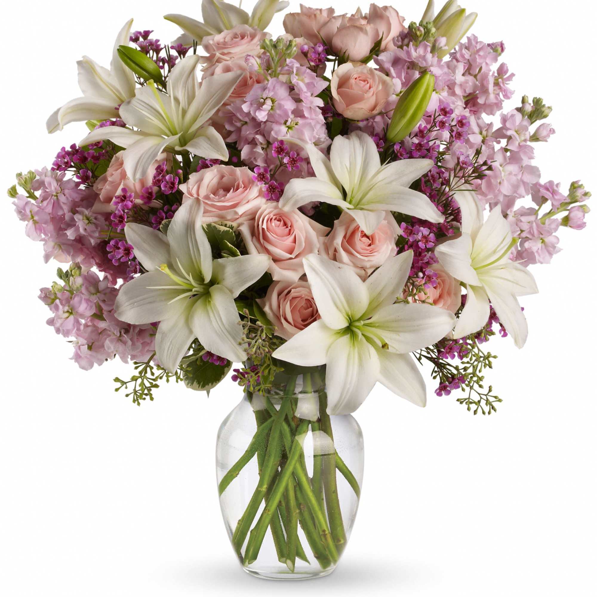 Pink roses and white lilies in a clear glass vase