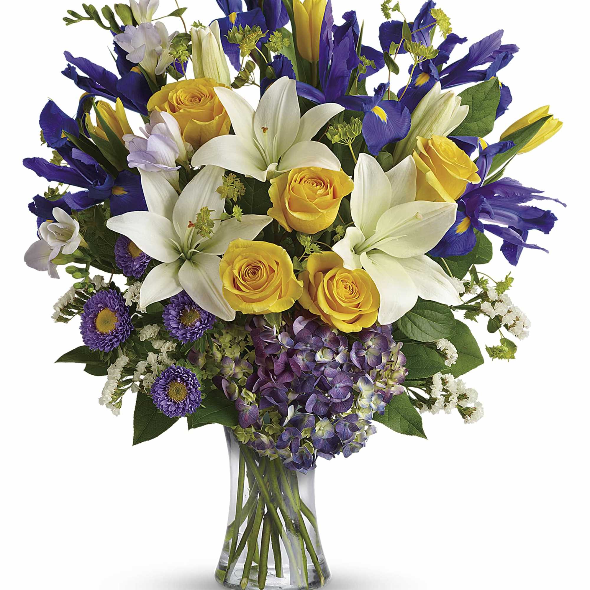 Bouquet of yellow roses, white lilies, and purple flowers in a glass vase