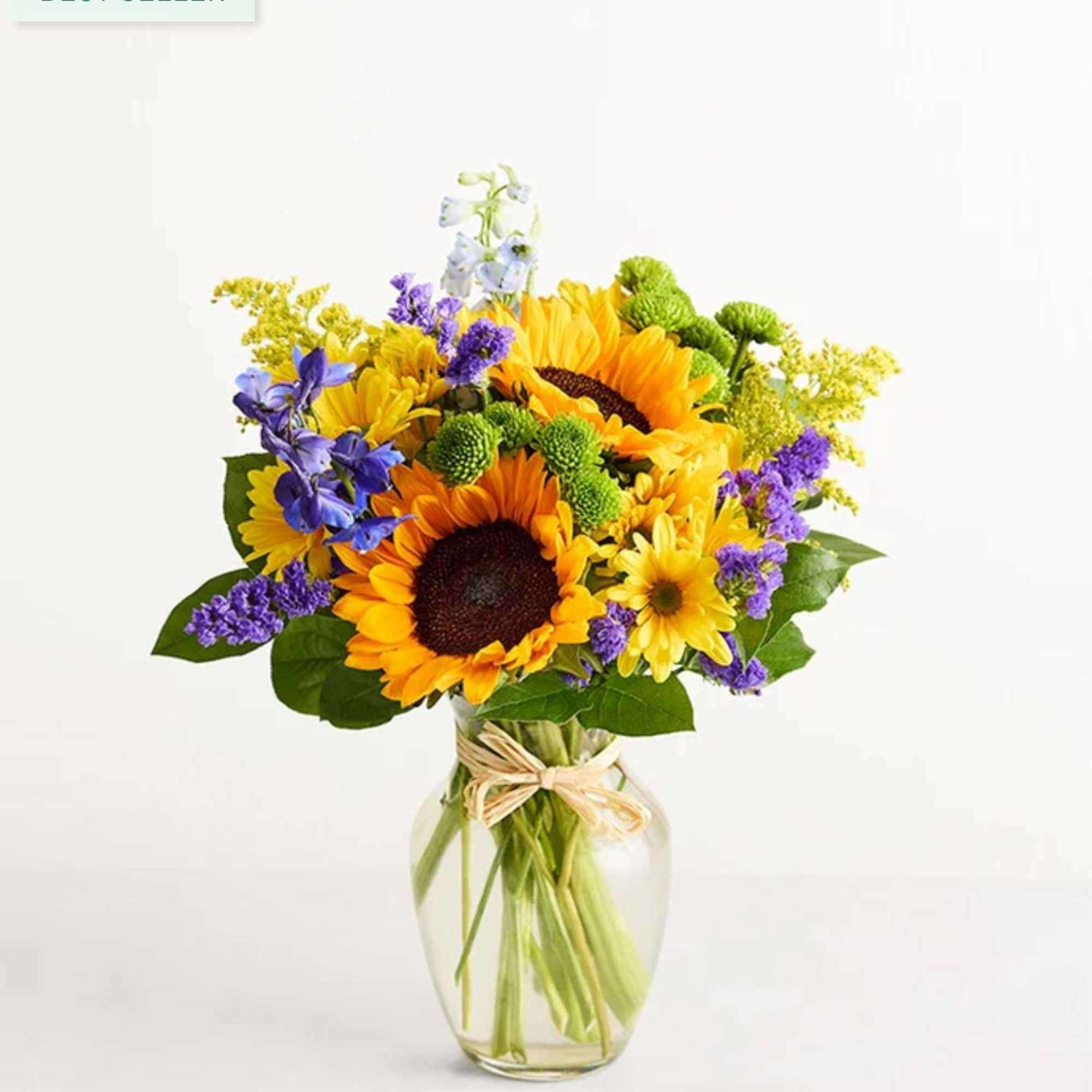 Sunflower bouquet in a clear glass vase with purple and yellow accents