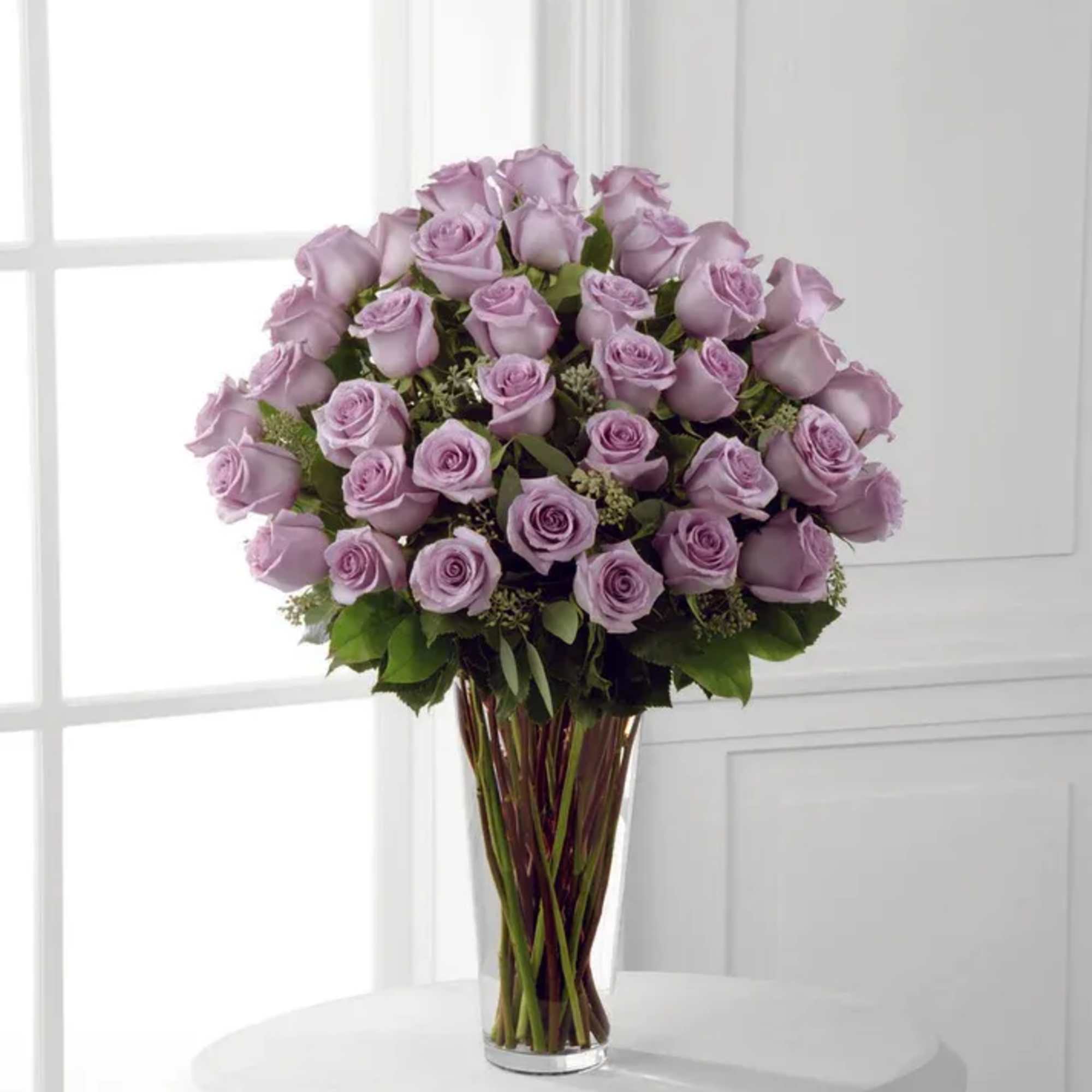 Lavender rose bouquet in a clear glass vase