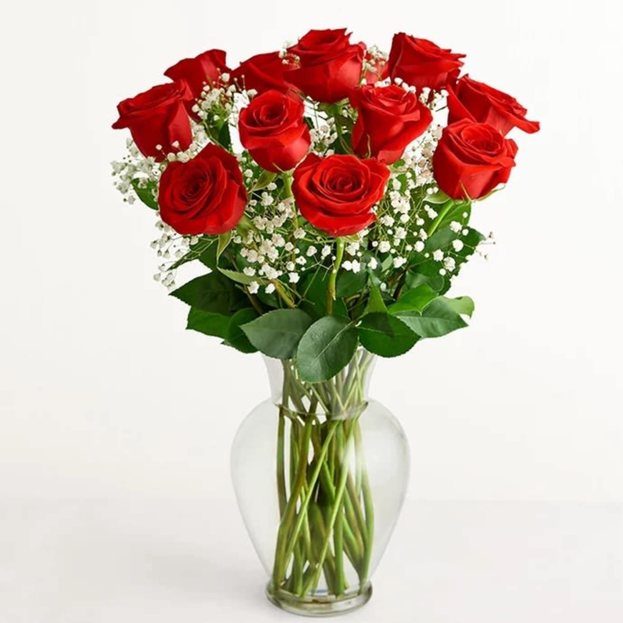Red roses arranged in a clear glass vase with white baby's breath