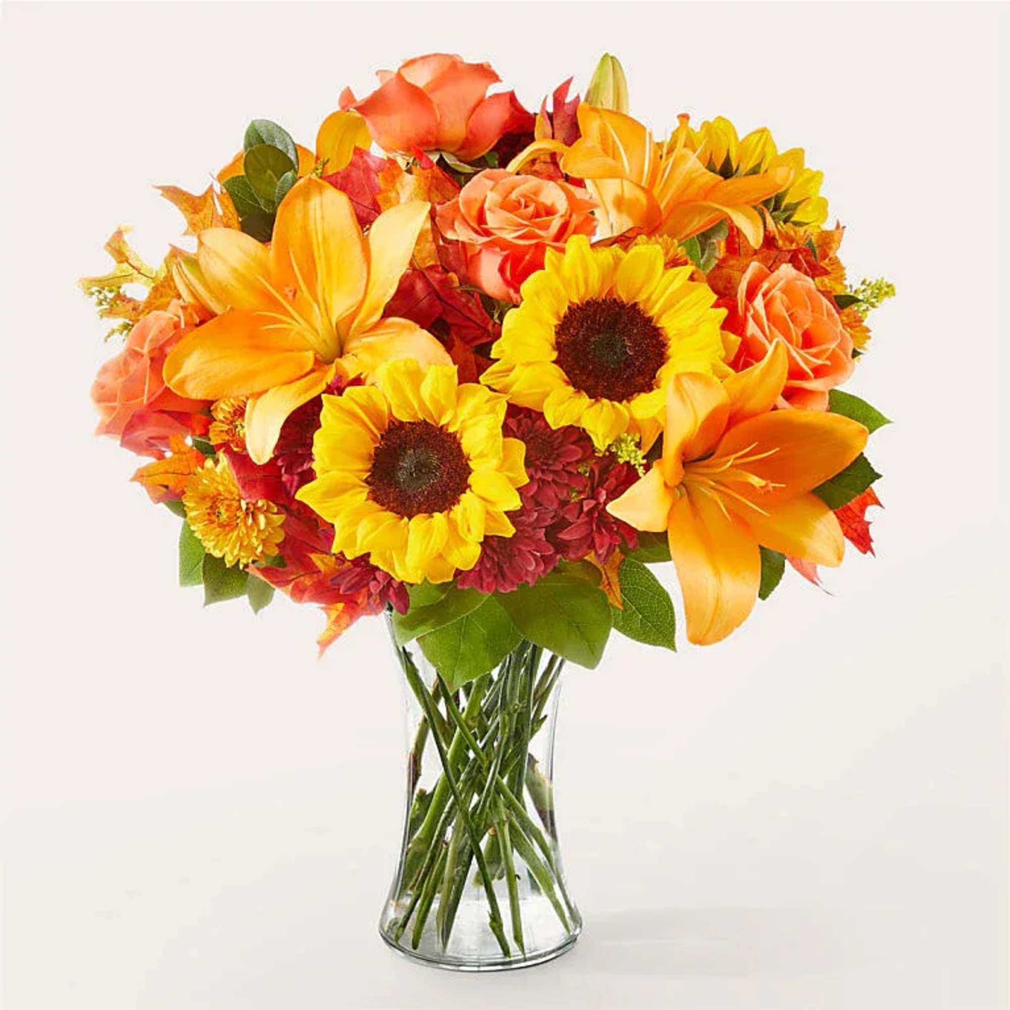 Orange and yellow mixed bouquet in a clear glass vase