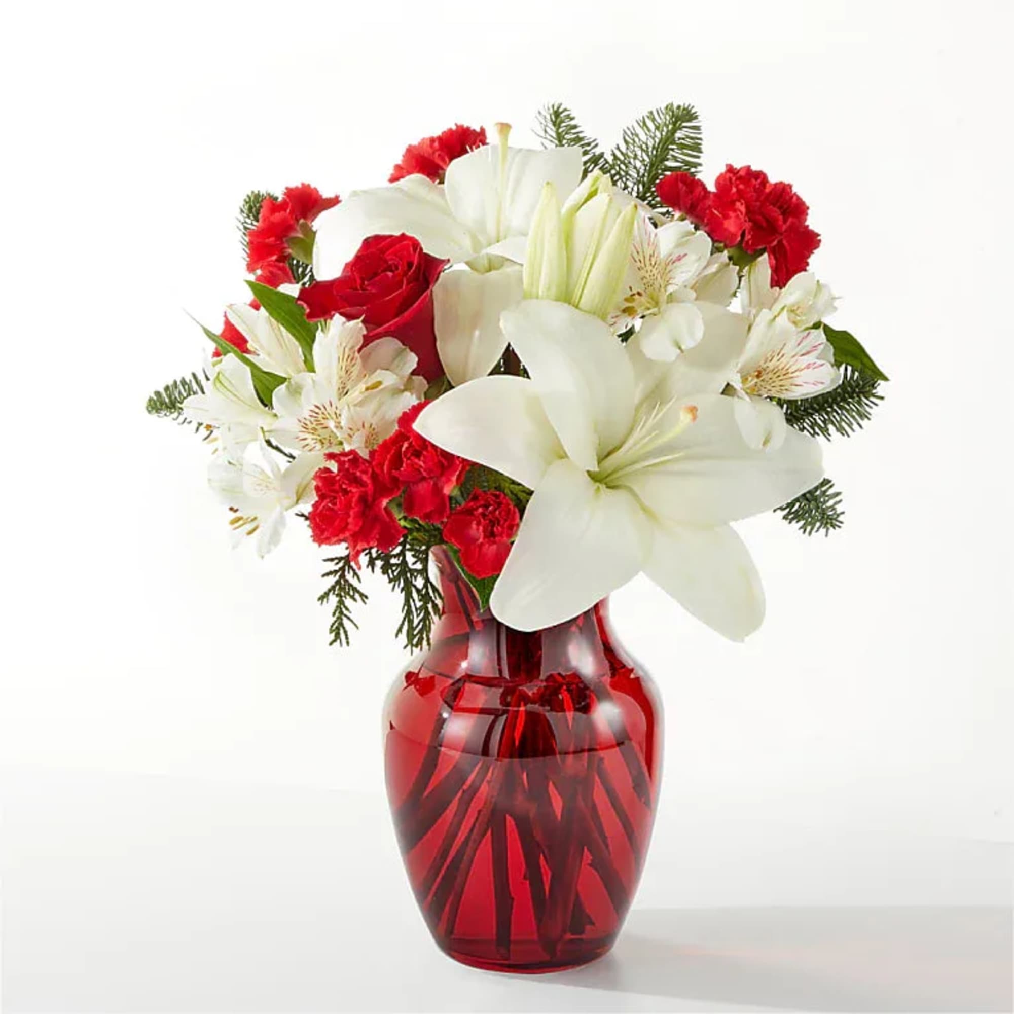 Red and white flowers arranged in a red glass vase
